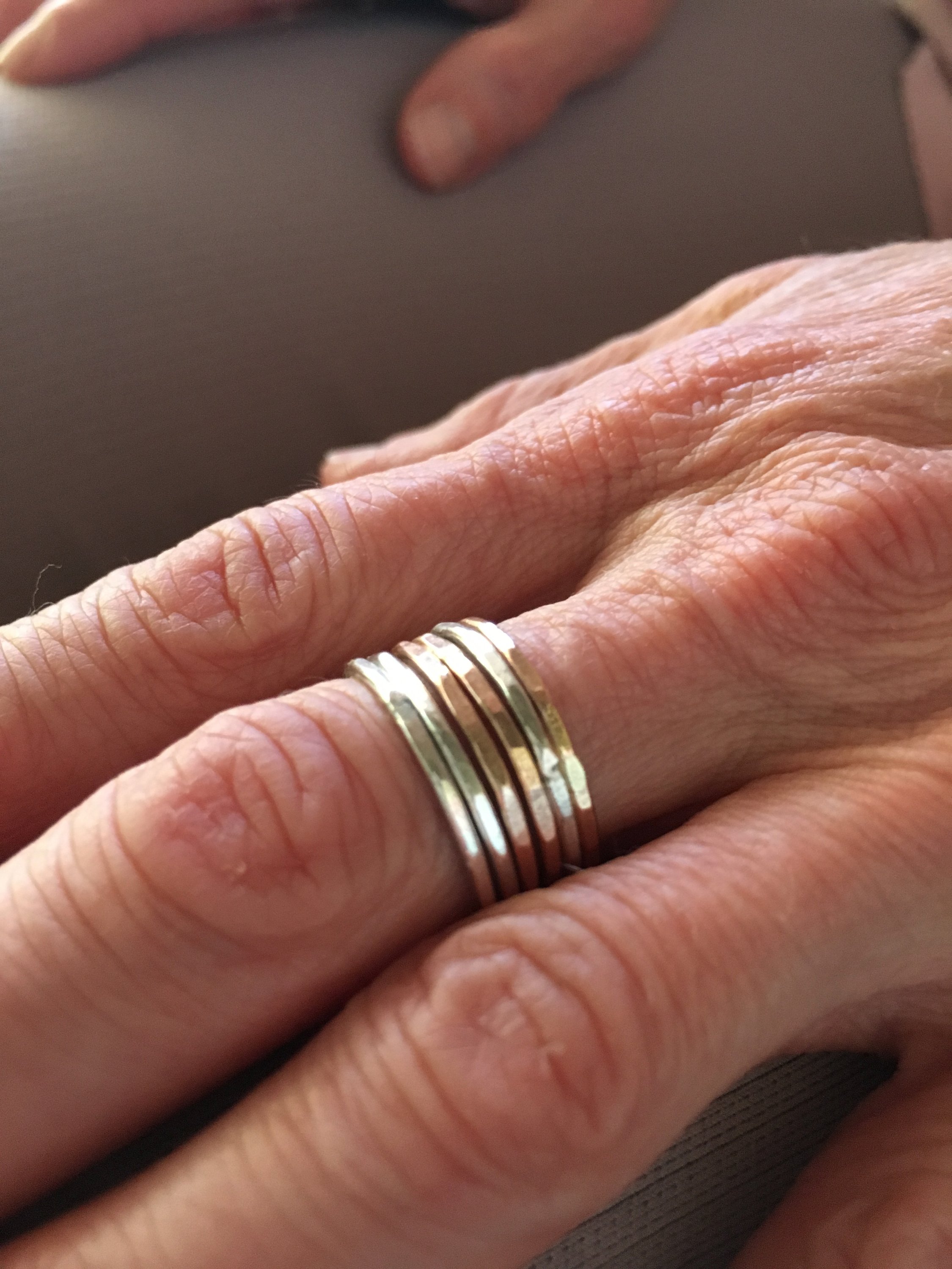 A set of Rustic Stacking Rings featuring a textured hammered finish, made from recycled metals in gold, rose gold, and silver.