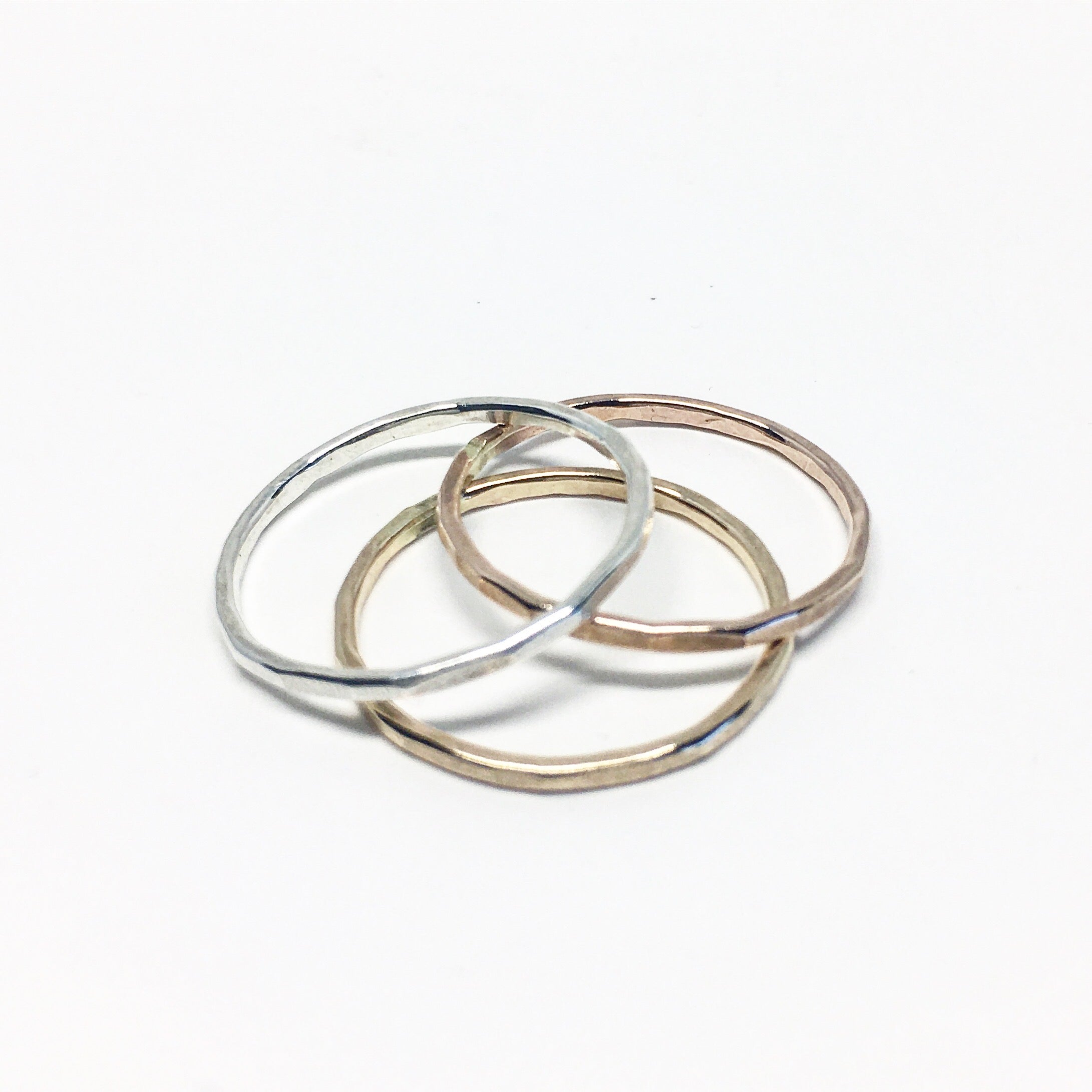 A set of Rustic Stacking Rings featuring a textured hammered finish, made from recycled metals in gold, rose gold, and silver.