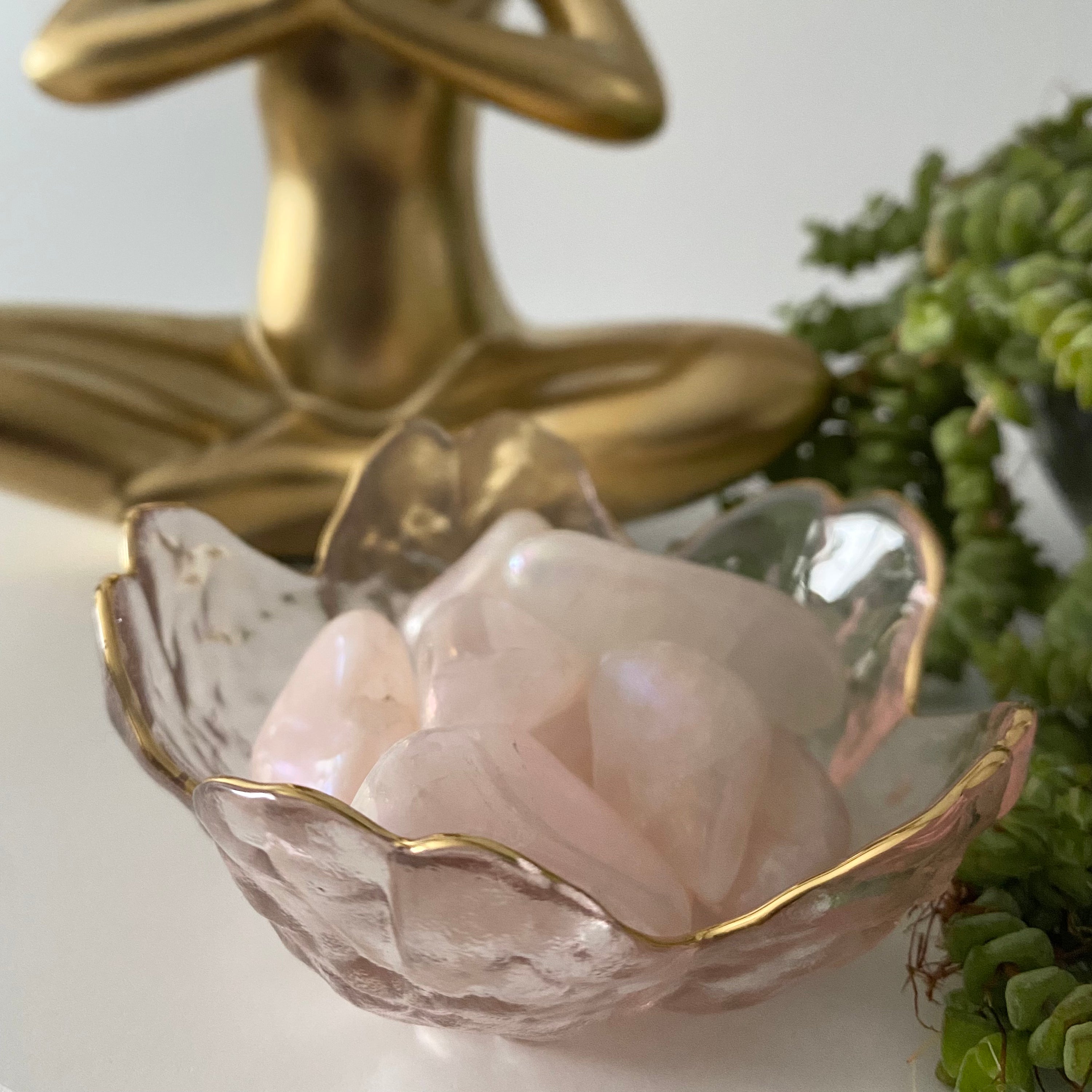 A delicate handmade hammered glass bowl shaped like a cherry blossom flower, perfect for holding trinkets.