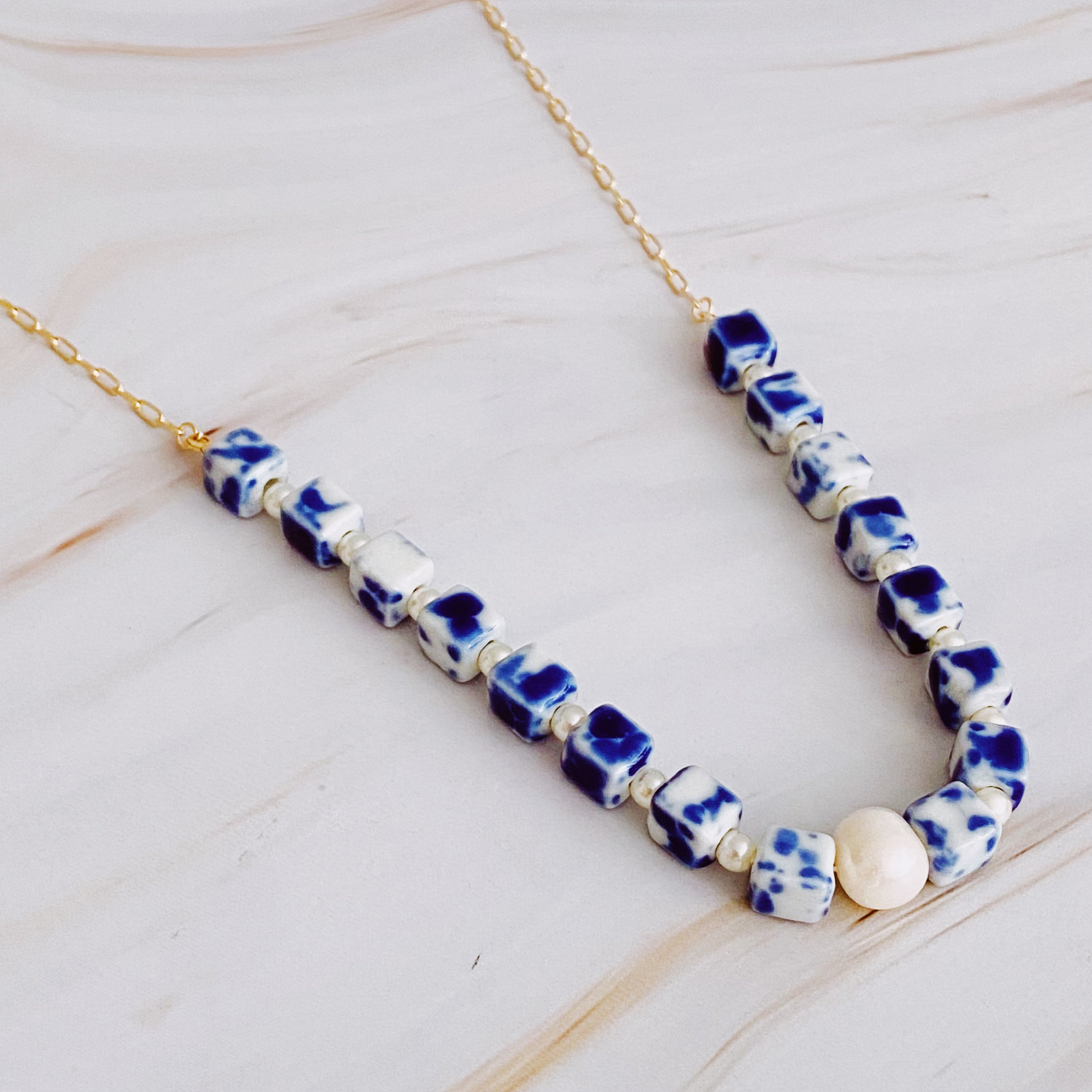 Santorini Touch Freshwater Pearl Necklace featuring a central pearl and colorful ceramic beads, elegantly designed with a gold-plated alloy chain.