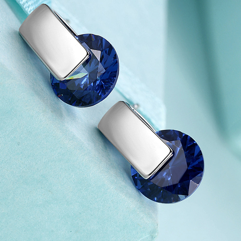 Elegant sapphire stud earrings set in 18K white gold plating, showcasing a rich blue color and a comfortable design.