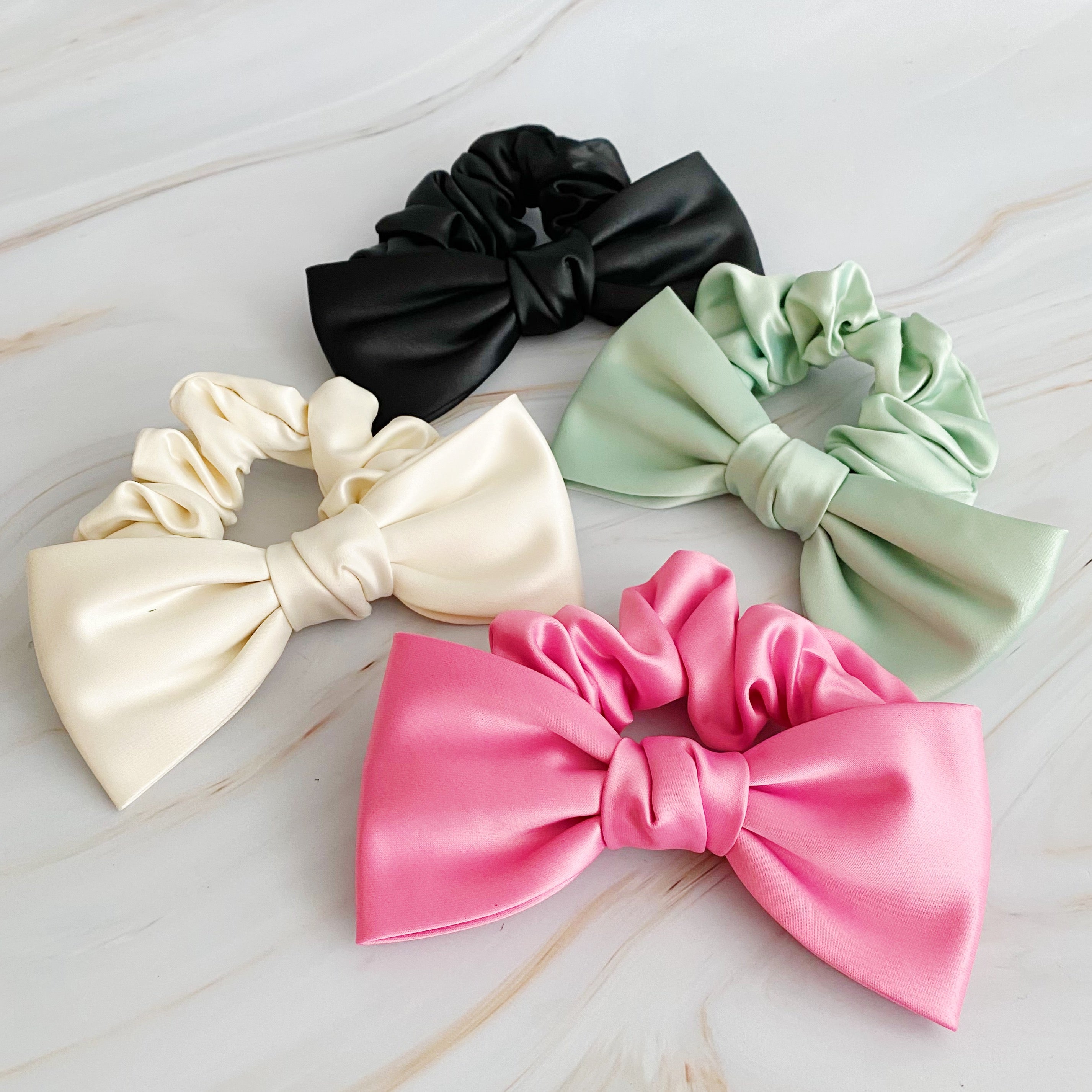 A stylish satin bow tie hair scrunchie in elegant colors, perfect for adding sophistication to any hairstyle.