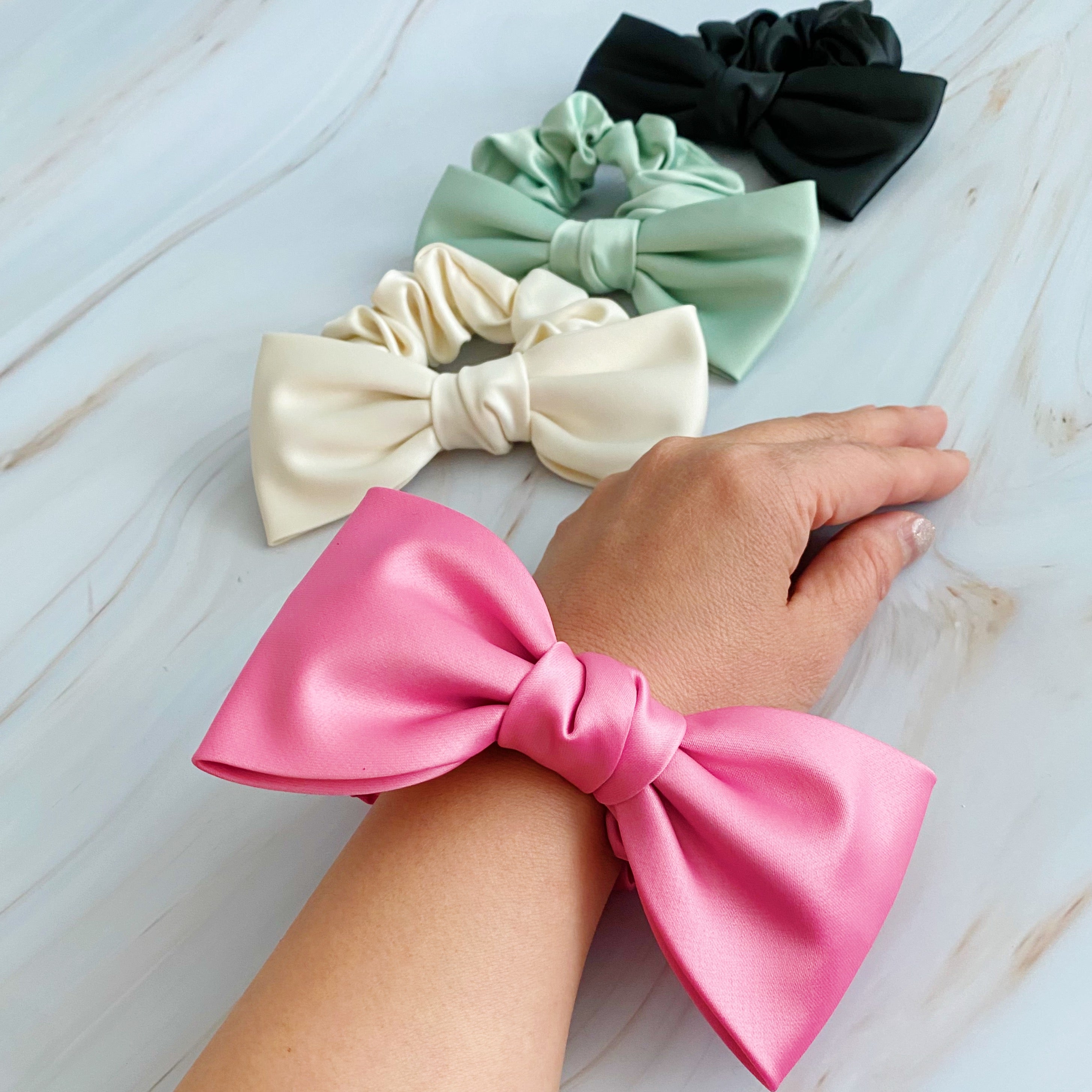 A stylish satin bow tie hair scrunchie in elegant colors, perfect for adding sophistication to any hairstyle.