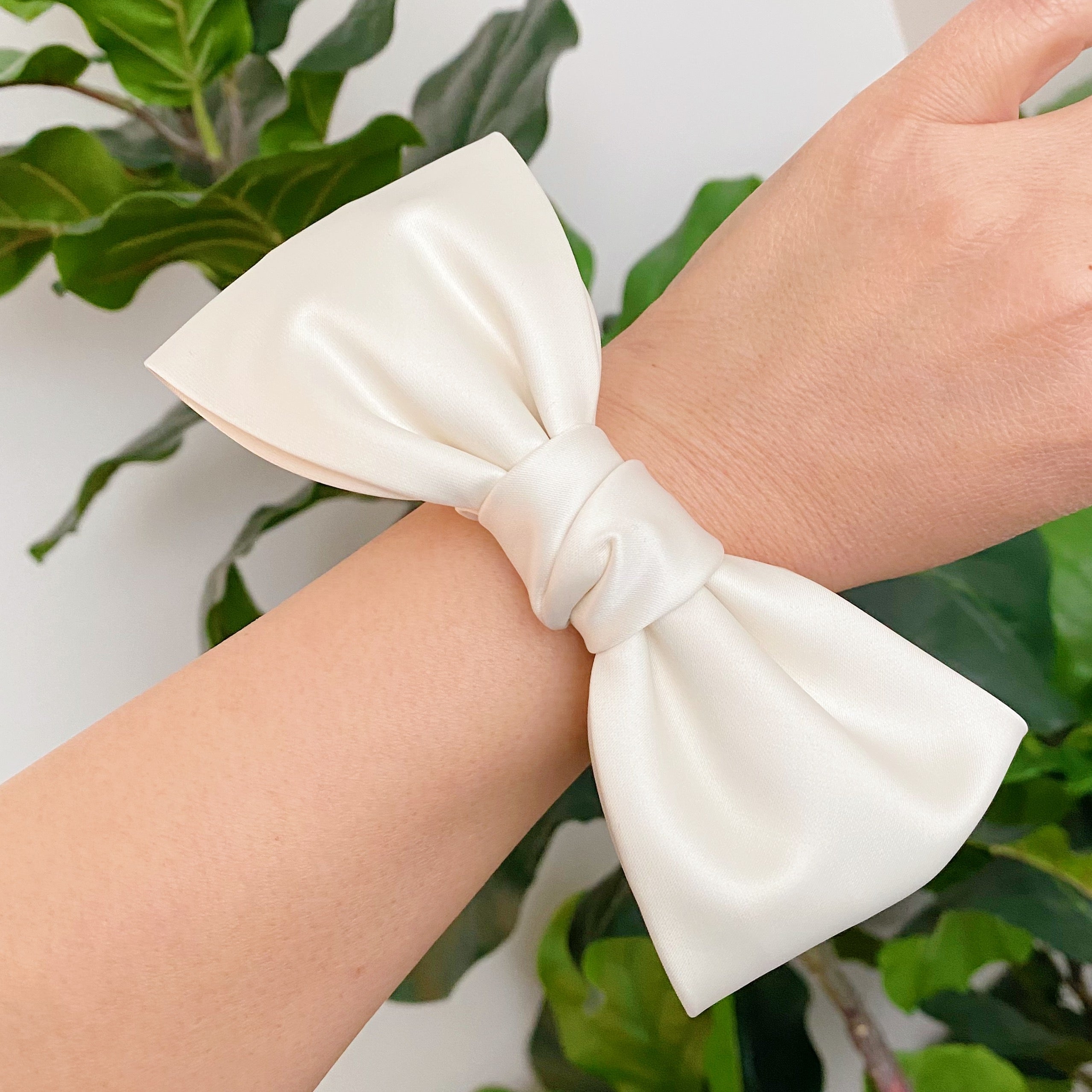 A stylish satin bow tie hair scrunchie in elegant colors, perfect for adding sophistication to any hairstyle.