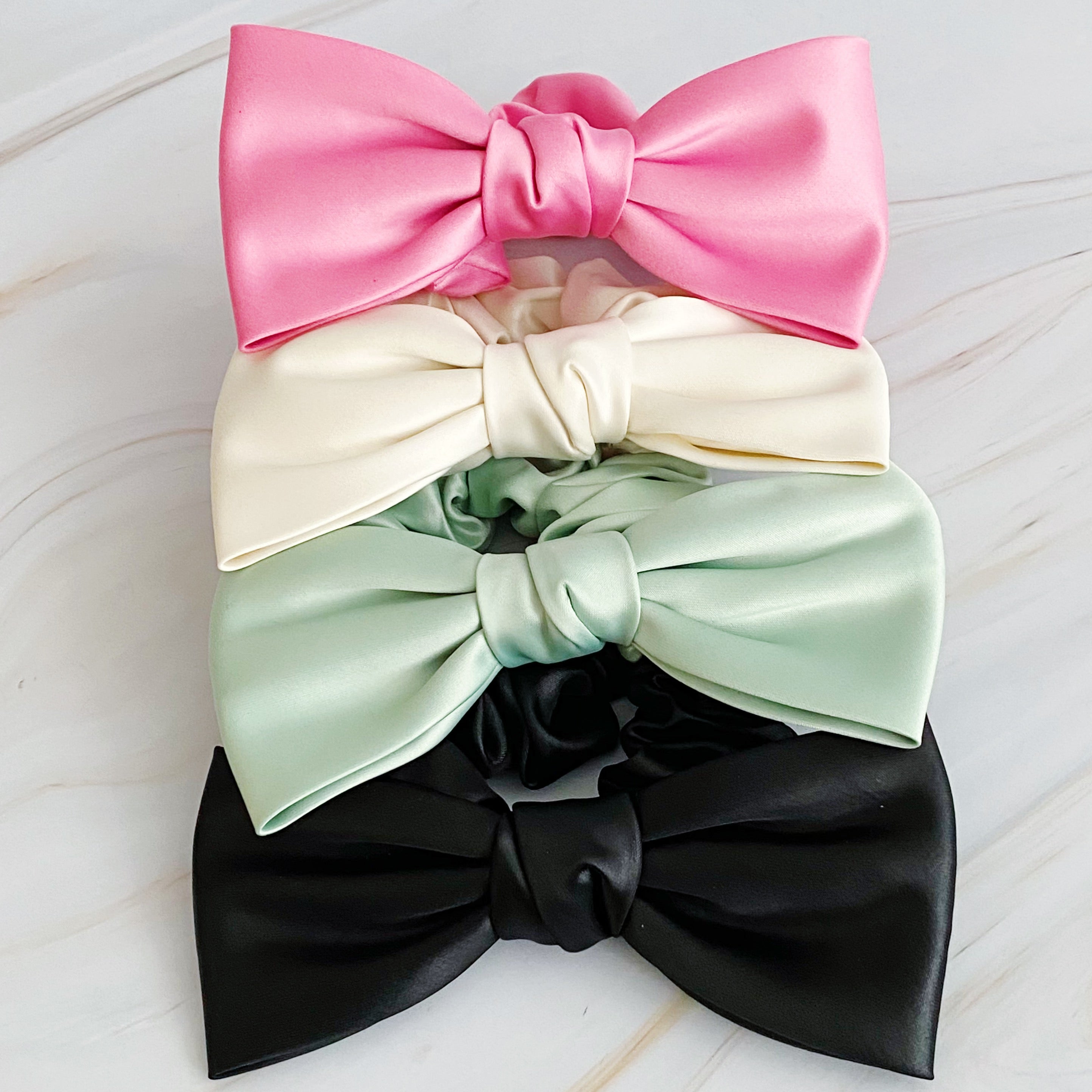 A stylish satin bow tie hair scrunchie in elegant colors, perfect for adding sophistication to any hairstyle.