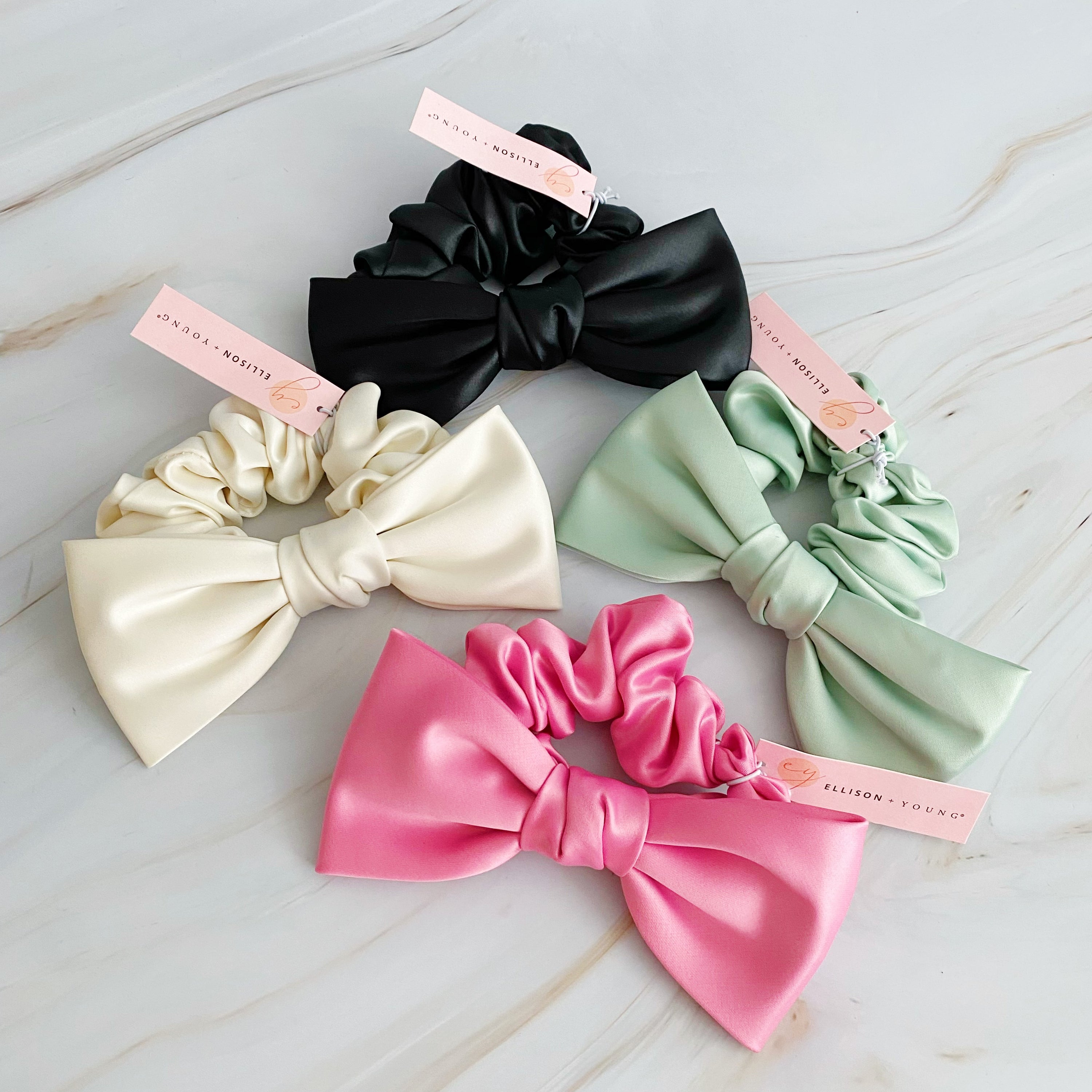 A stylish satin bow tie hair scrunchie in elegant colors, perfect for adding sophistication to any hairstyle.