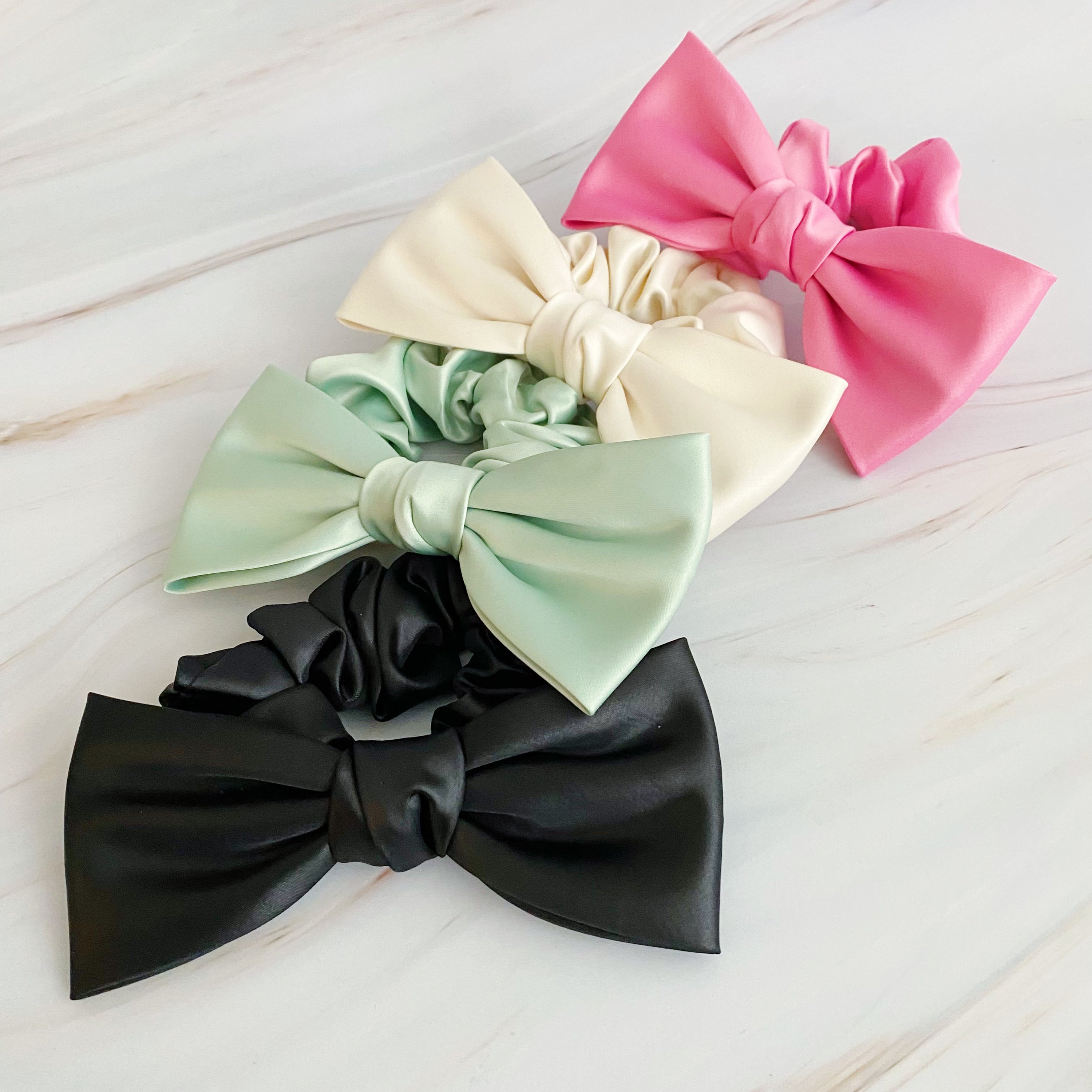 A stylish satin bow tie hair scrunchie in elegant colors, perfect for adding sophistication to any hairstyle.