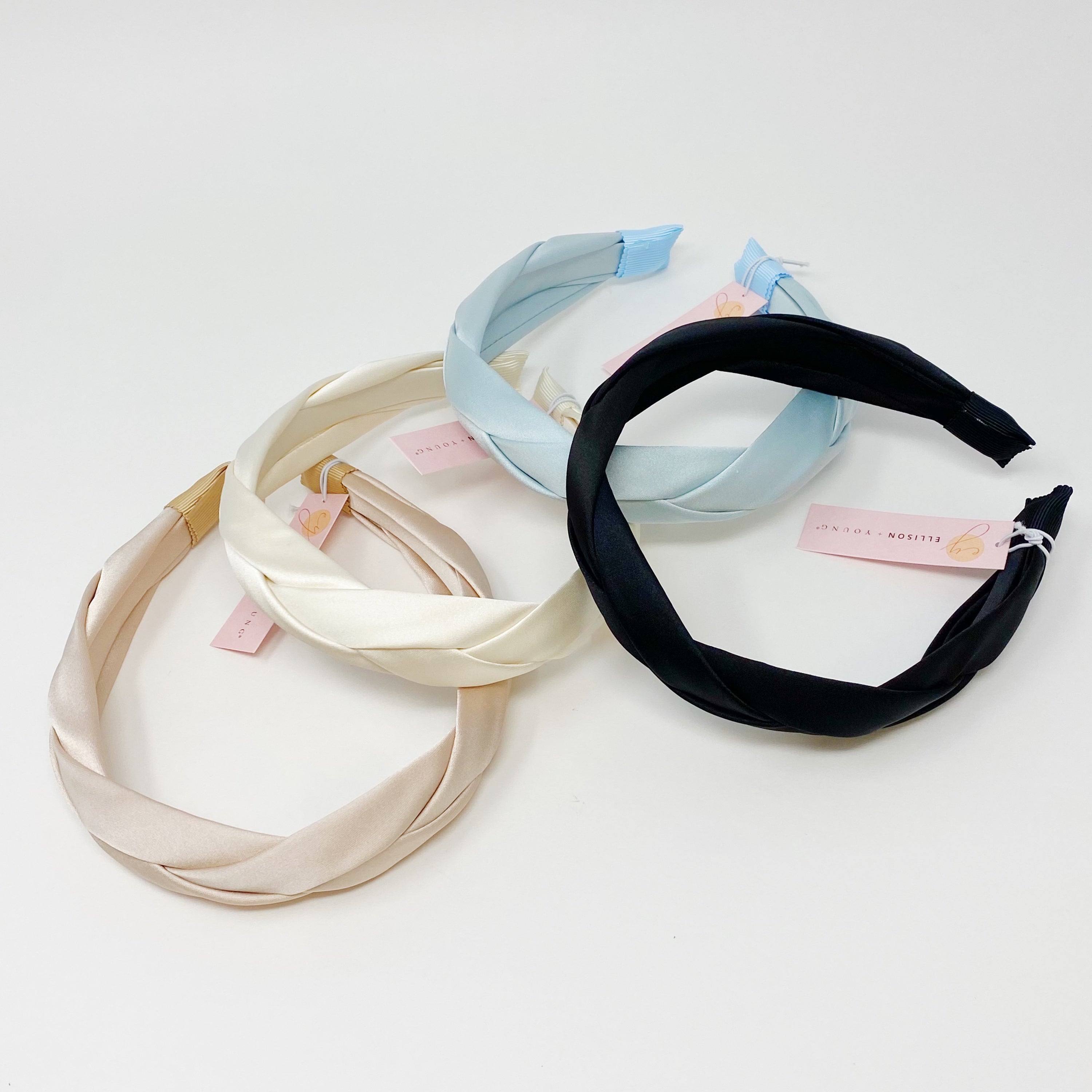 A luxurious satin silk braid headband featuring a twisted design, perfect for adding elegance to any hairstyle.