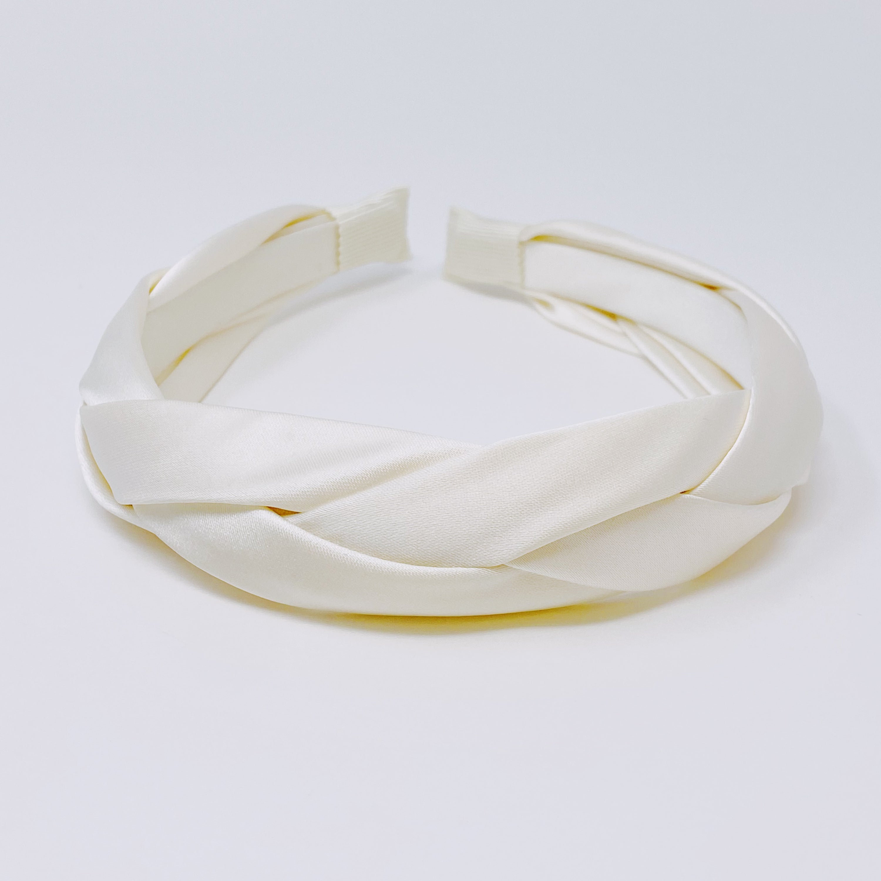 A luxurious satin silk braid headband featuring a twisted design, perfect for adding elegance to any hairstyle.