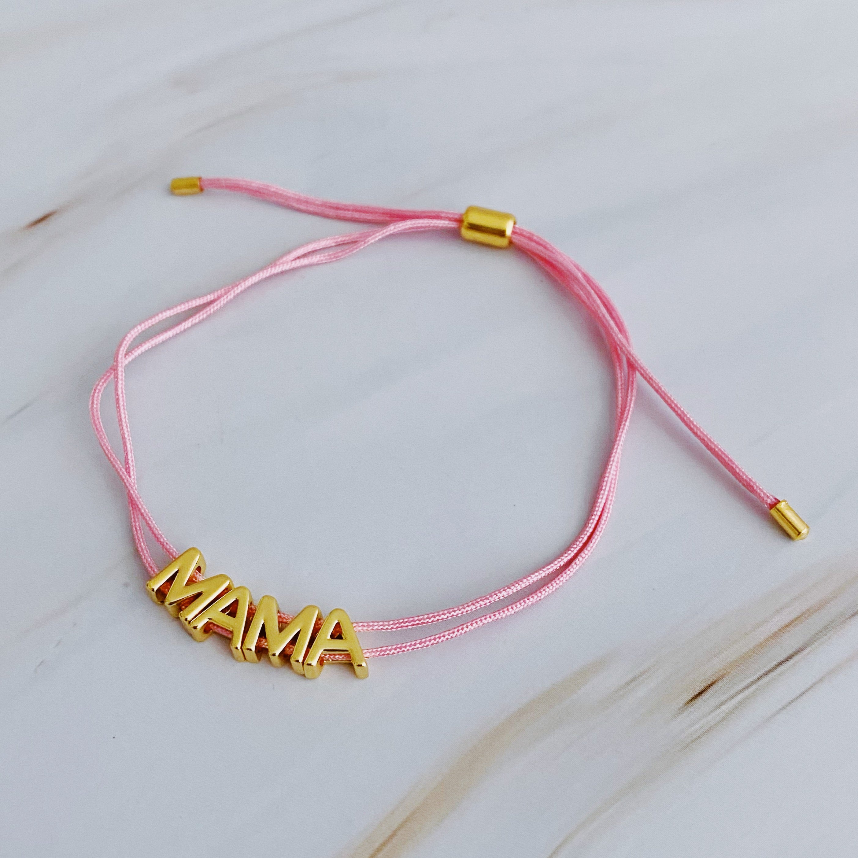 A stylish Satin Thread Mama Bracelet featuring a slim satin thread with golden 'MAMA' lettering, adjustable for a perfect fit.