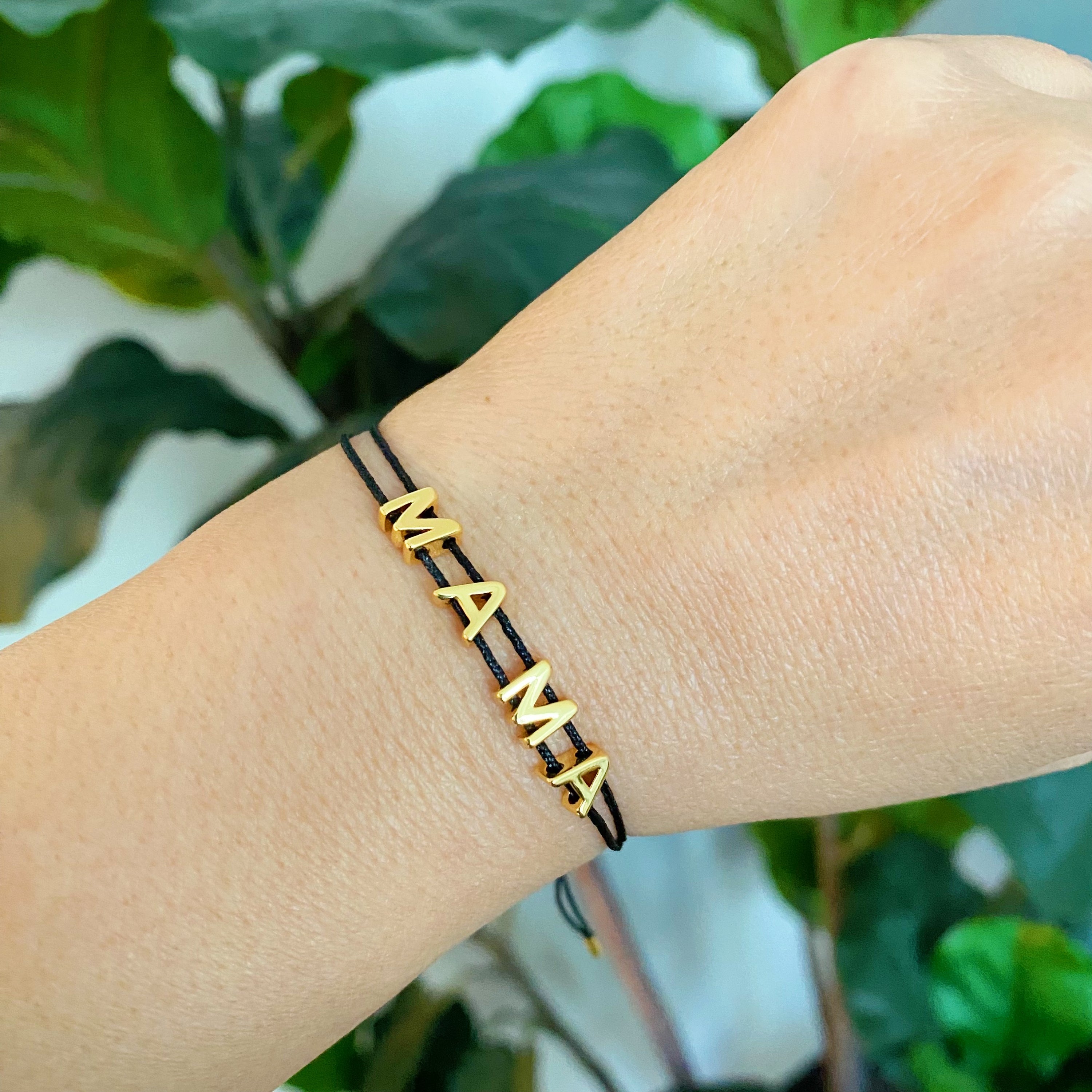 A stylish Satin Thread Mama Bracelet featuring a slim satin thread with golden 'MAMA' lettering, adjustable for a perfect fit.