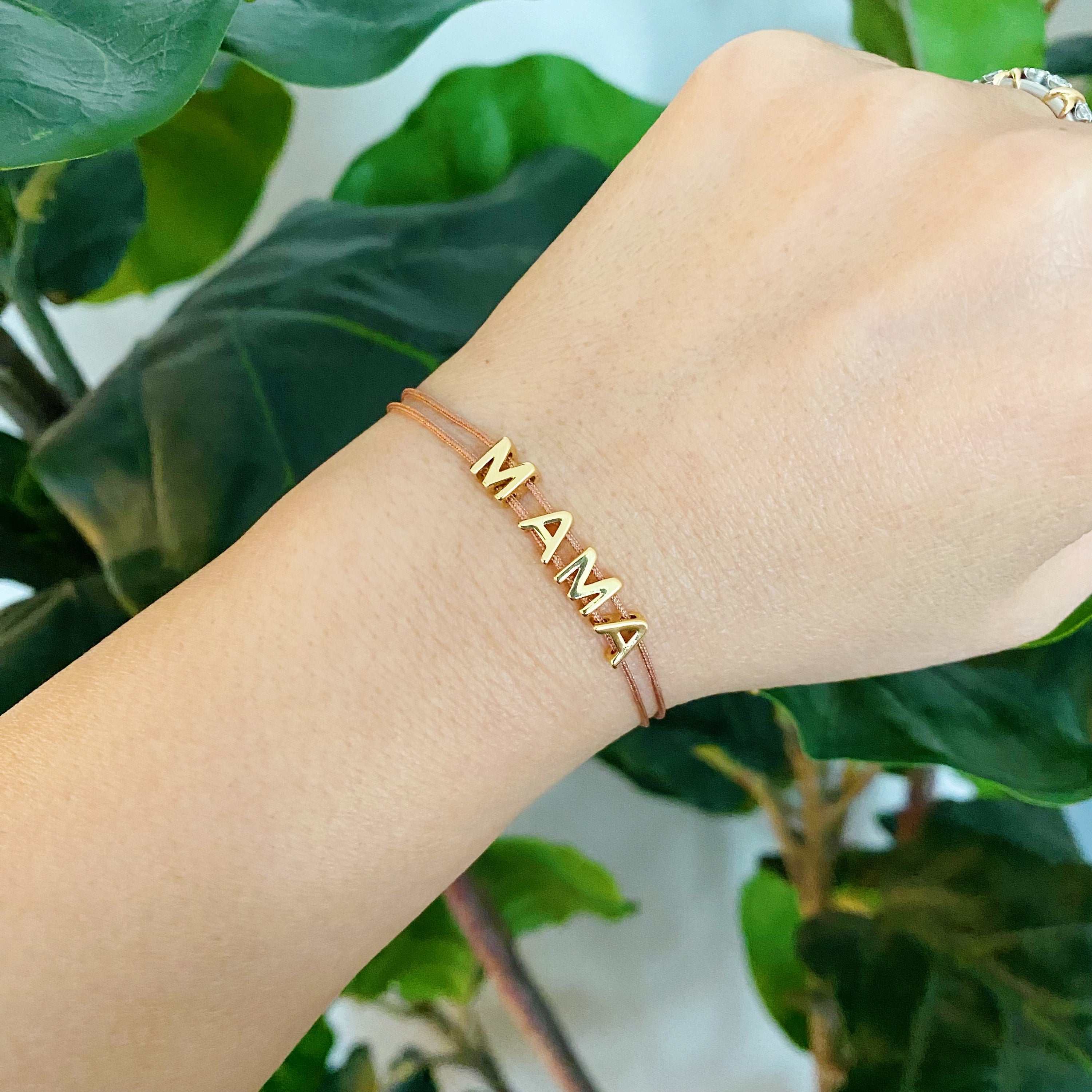 A stylish Satin Thread Mama Bracelet featuring a slim satin thread with golden 'MAMA' lettering, adjustable for a perfect fit.