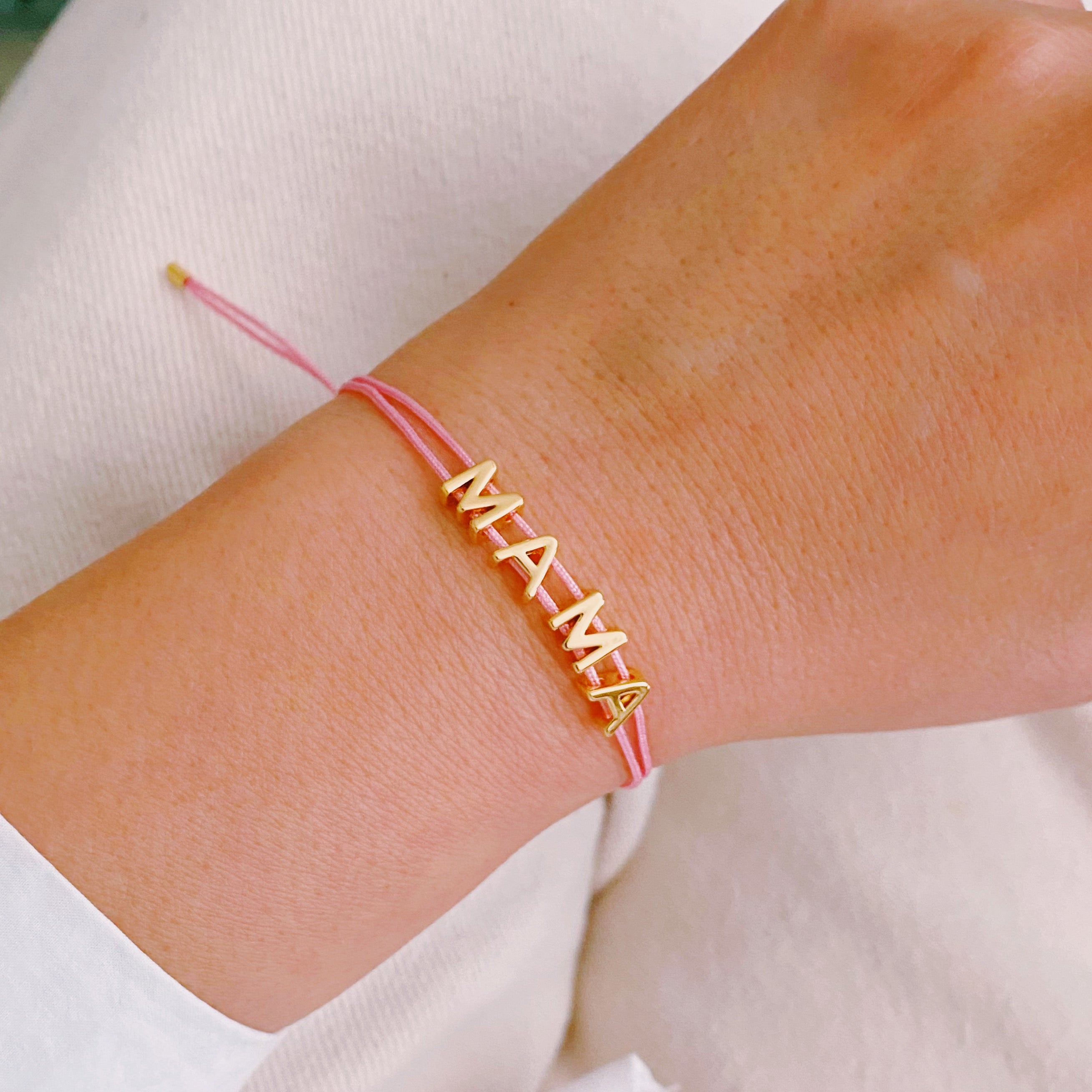 A stylish Satin Thread Mama Bracelet featuring a slim satin thread with golden 'MAMA' lettering, adjustable for a perfect fit.