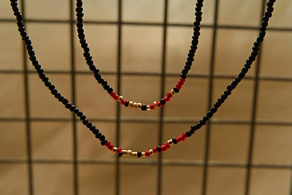 Handcrafted seed bead bracelet featuring the word 'focus' in morse code with red, gold, and black beads.