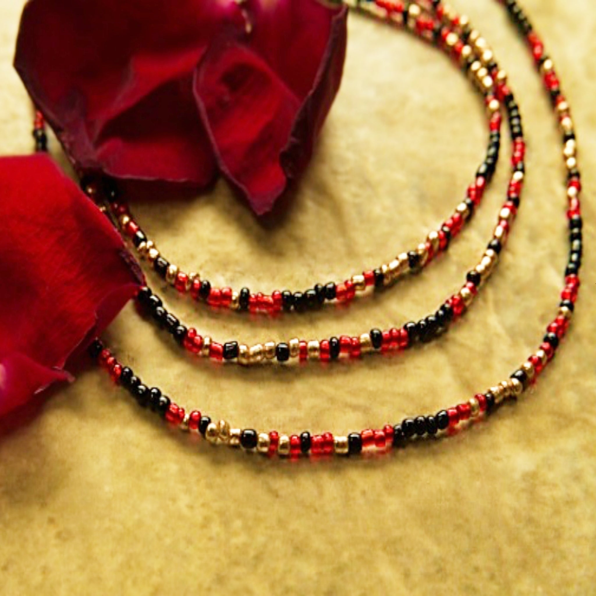 Handcrafted seed bead bracelet featuring the word 'focus' in morse code with red, gold, and black beads.