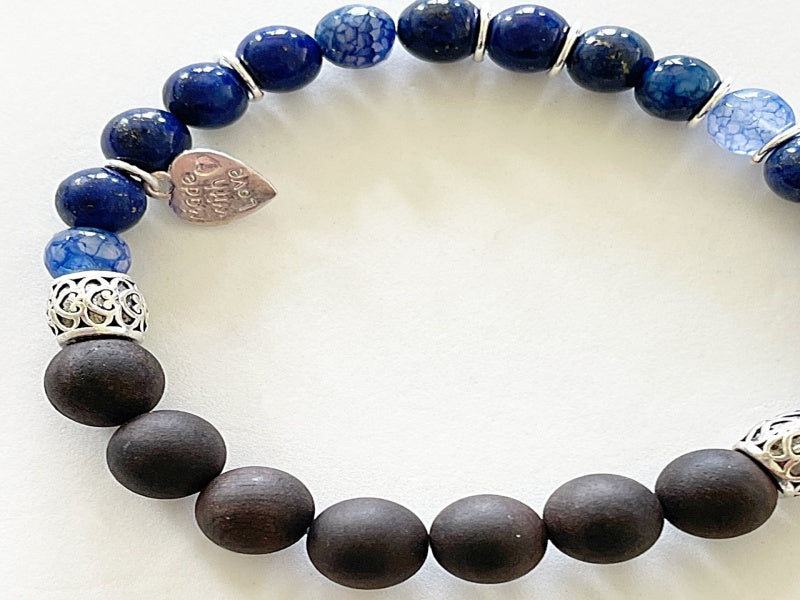 A stylish stretch bracelet featuring Morse Code spelling 'Breathe!' with green Aventurine, sesame jasper, and blue lapis lazuli gemstones.