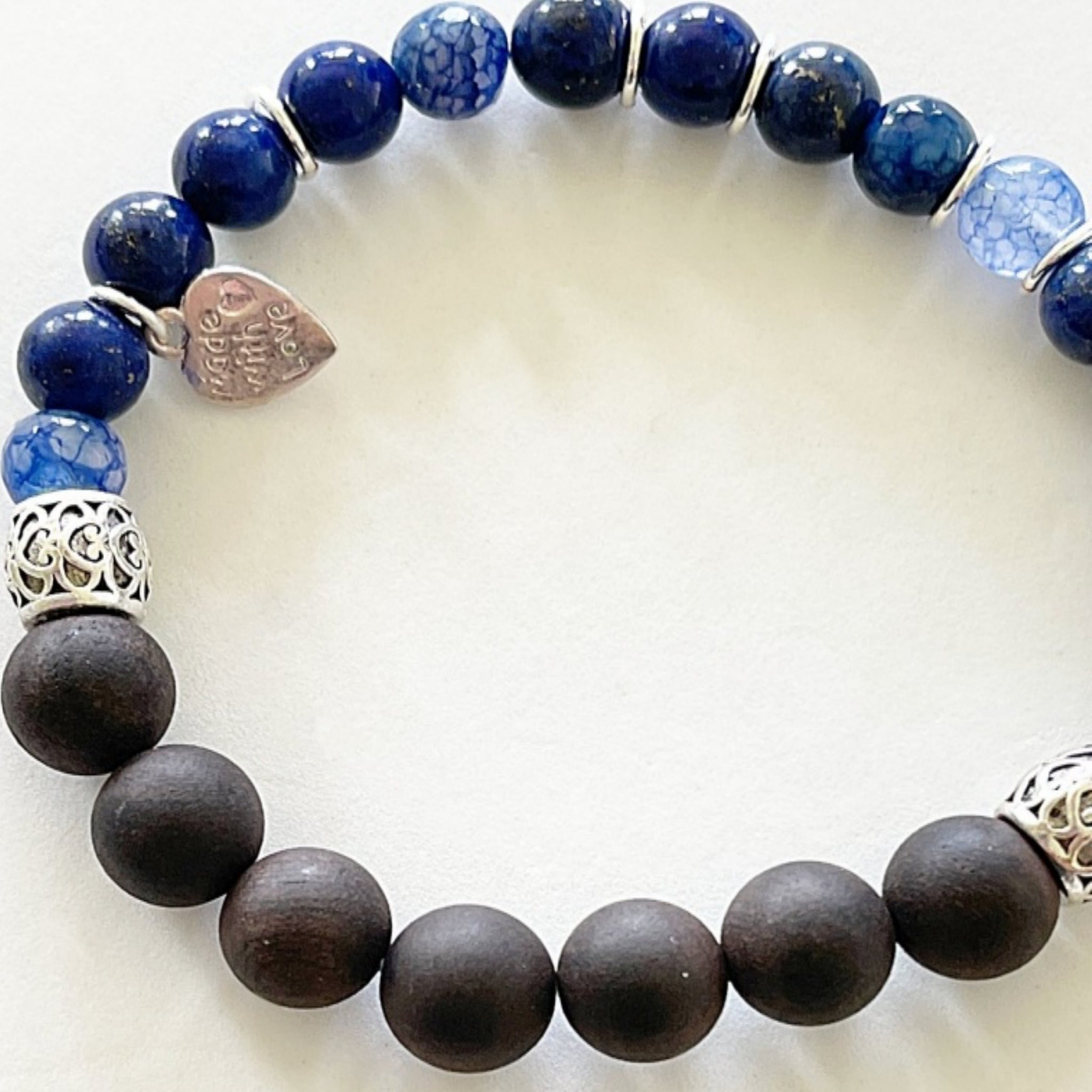 A stylish stretch bracelet featuring Morse Code spelling 'Breathe!' with green Aventurine, sesame jasper, and blue lapis lazuli gemstones.