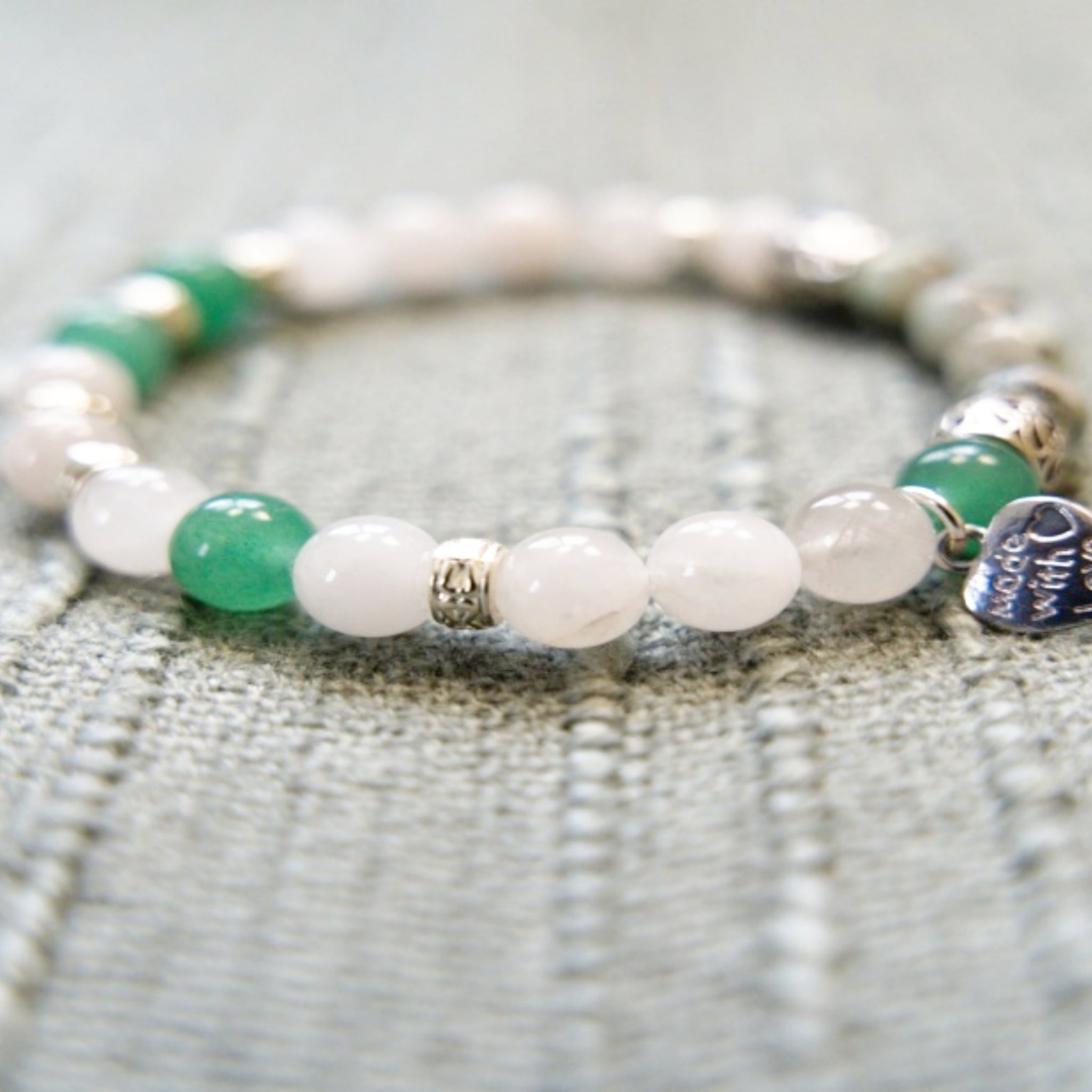 A stylish stretch bracelet featuring Morse Code spelling 'Breathe!' with green Aventurine, sesame jasper, and blue lapis lazuli gemstones.