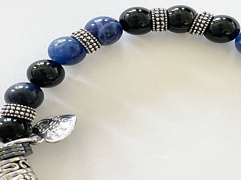 A stylish stretch bracelet featuring Morse Code spelling 'Breathe!' with green Aventurine, sesame jasper, and blue lapis lazuli gemstones.