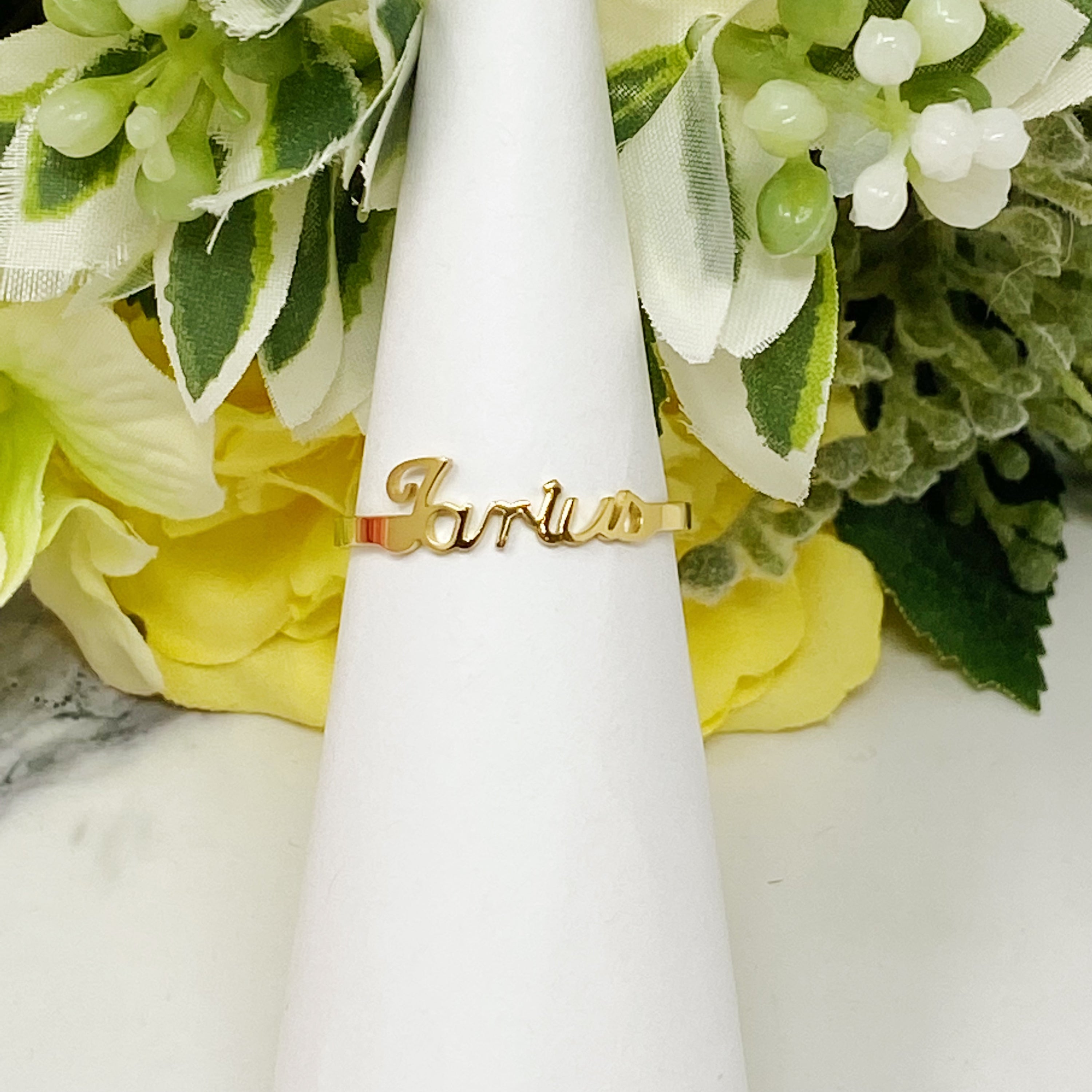 A beautifully crafted adjustable ring featuring delicately scripted zodiac signs, made of stainless steel and 18K gold plated.