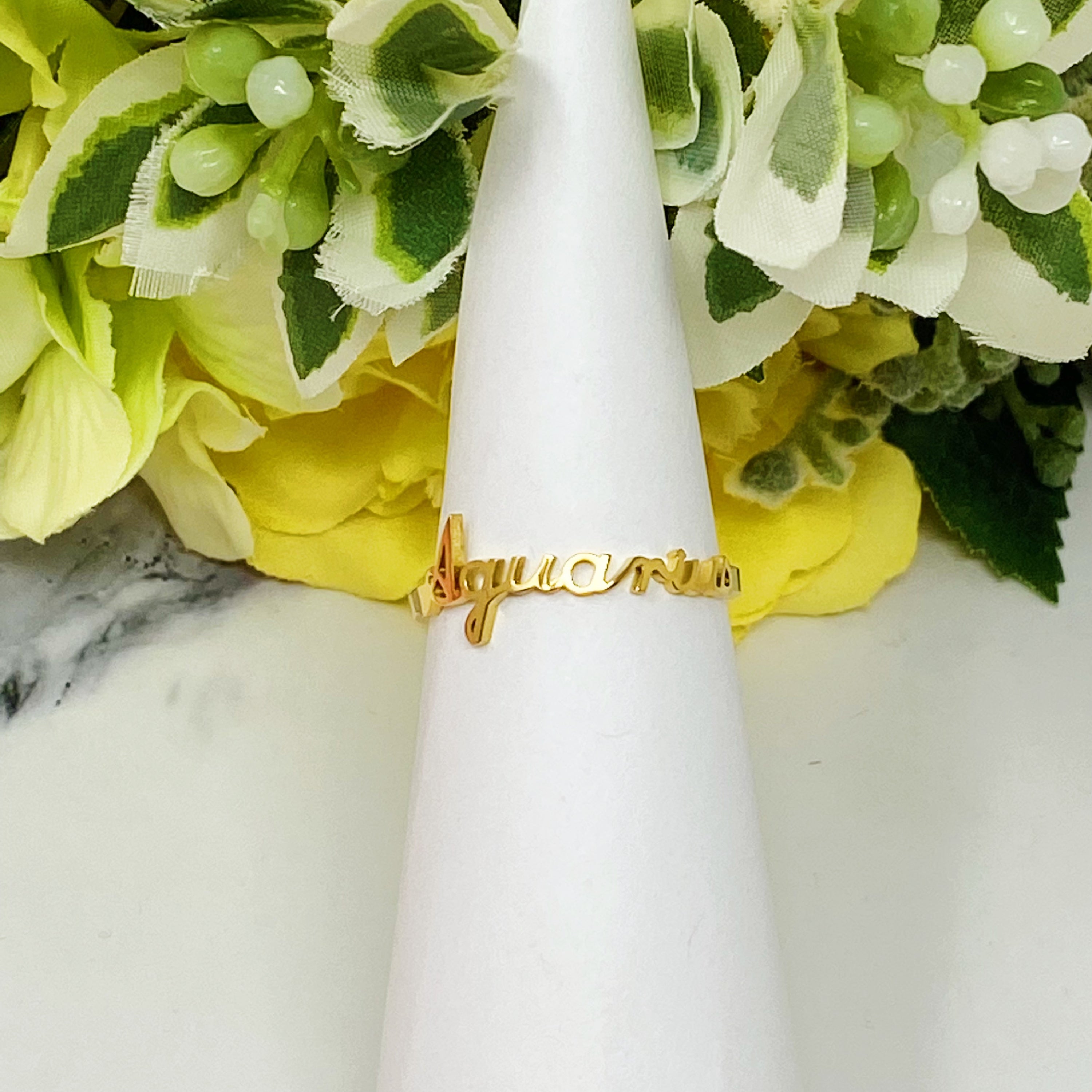 A beautifully crafted adjustable ring featuring delicately scripted zodiac signs, made of stainless steel and 18K gold plated.