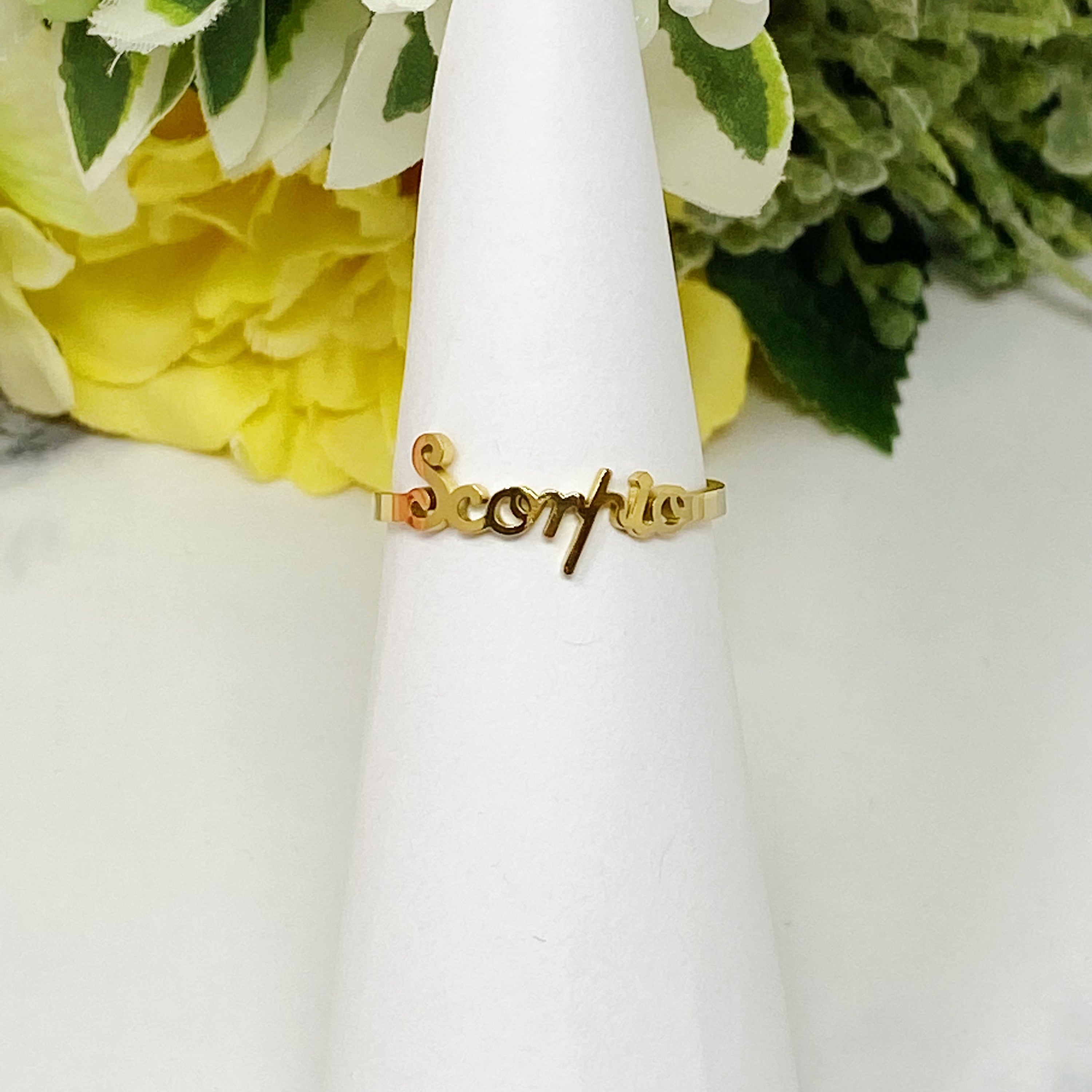 A beautifully crafted adjustable ring featuring delicately scripted zodiac signs, made of stainless steel and 18K gold plated.