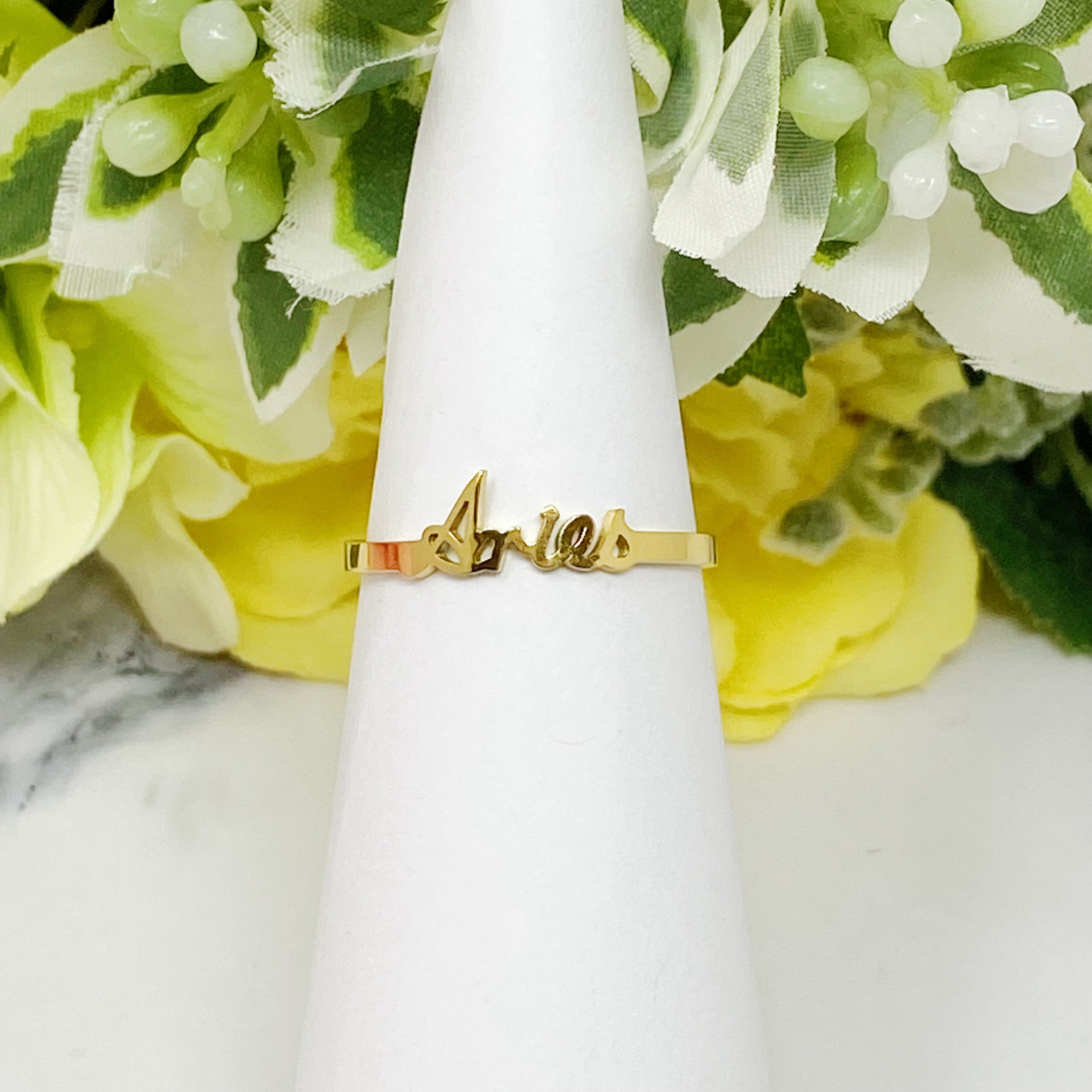 A beautifully crafted adjustable ring featuring delicately scripted zodiac signs, made of stainless steel and 18K gold plated.