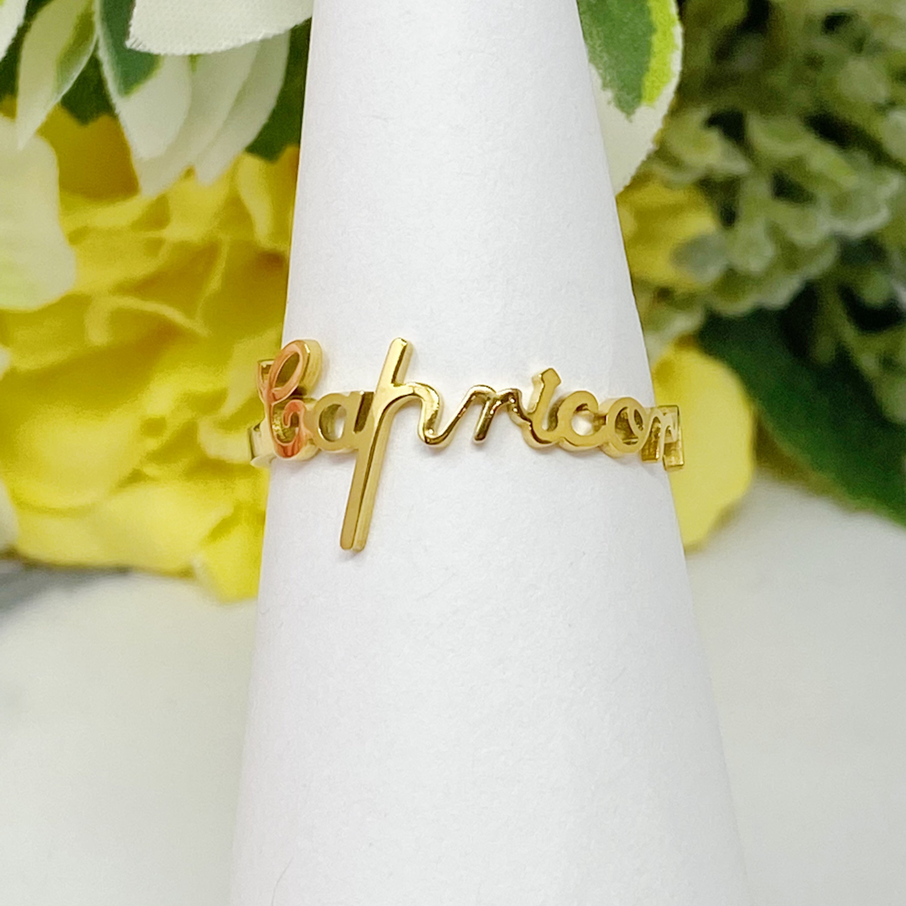 A beautifully crafted adjustable ring featuring delicately scripted zodiac signs, made of stainless steel and 18K gold plated.