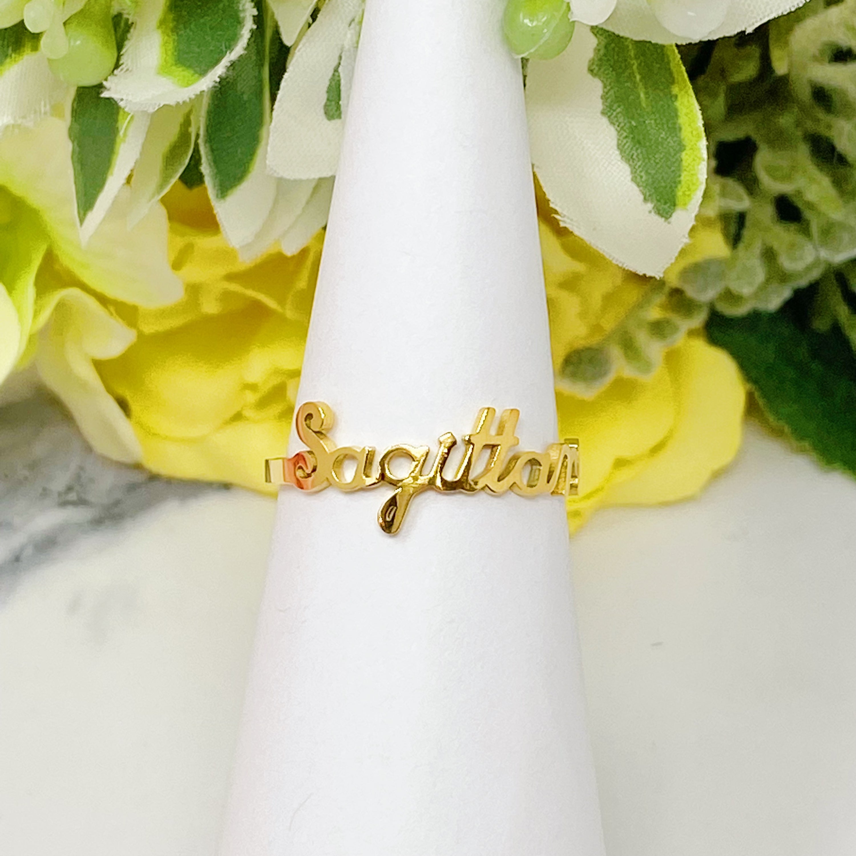 A beautifully crafted adjustable ring featuring delicately scripted zodiac signs, made of stainless steel and 18K gold plated.