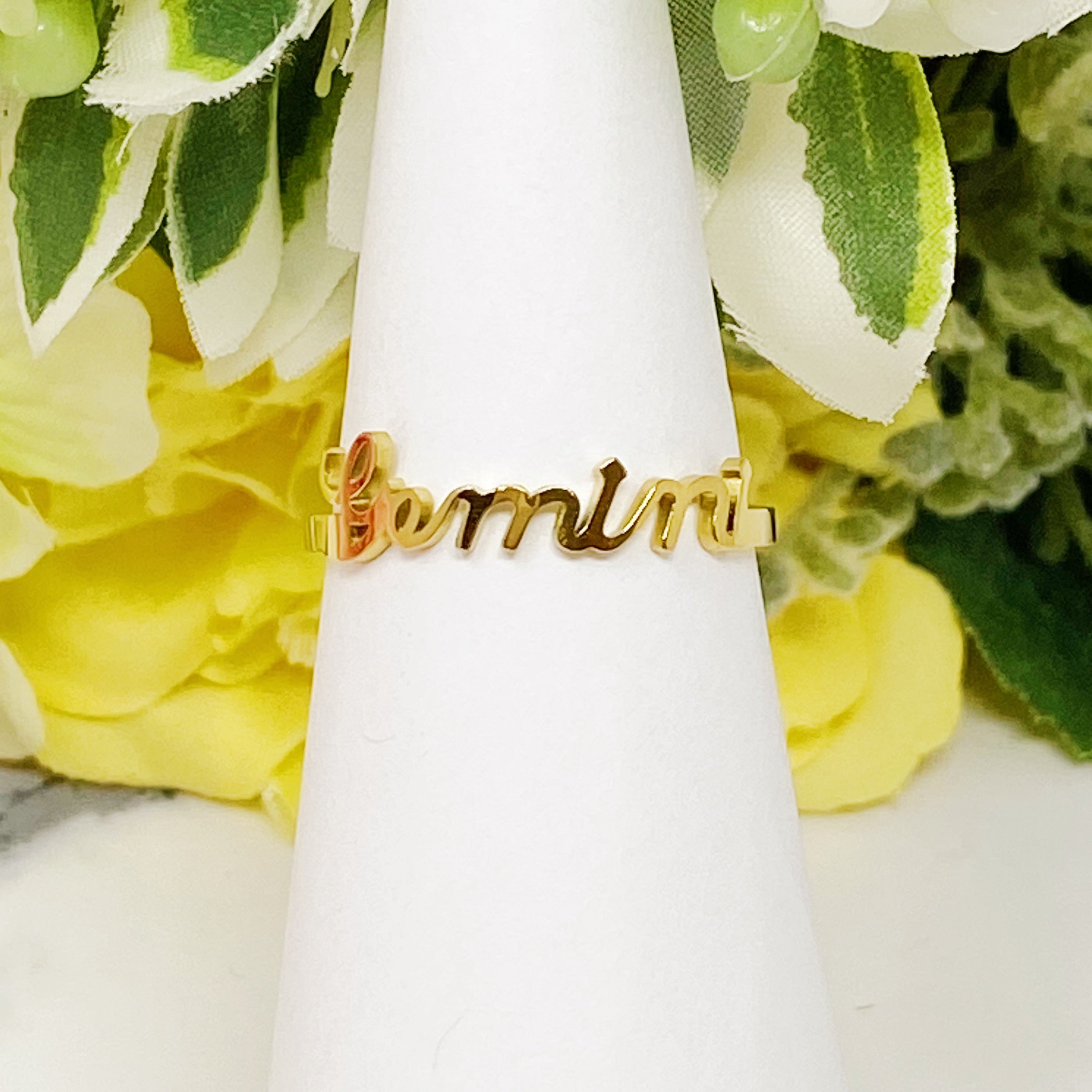 A beautifully crafted adjustable ring featuring delicately scripted zodiac signs, made of stainless steel and 18K gold plated.