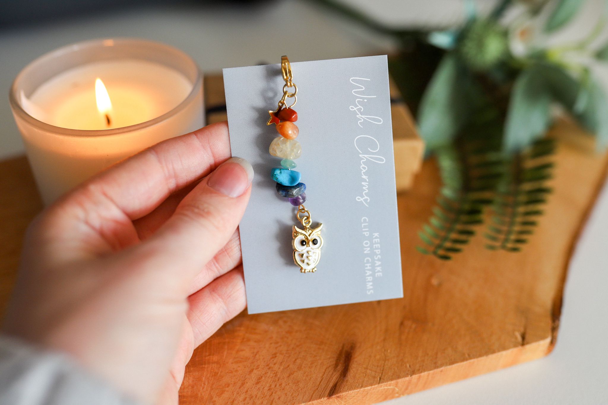 A beautiful Sea Shell Wish Charm featuring glass beads and Tibetan silver, elegantly displayed on a glossy card.