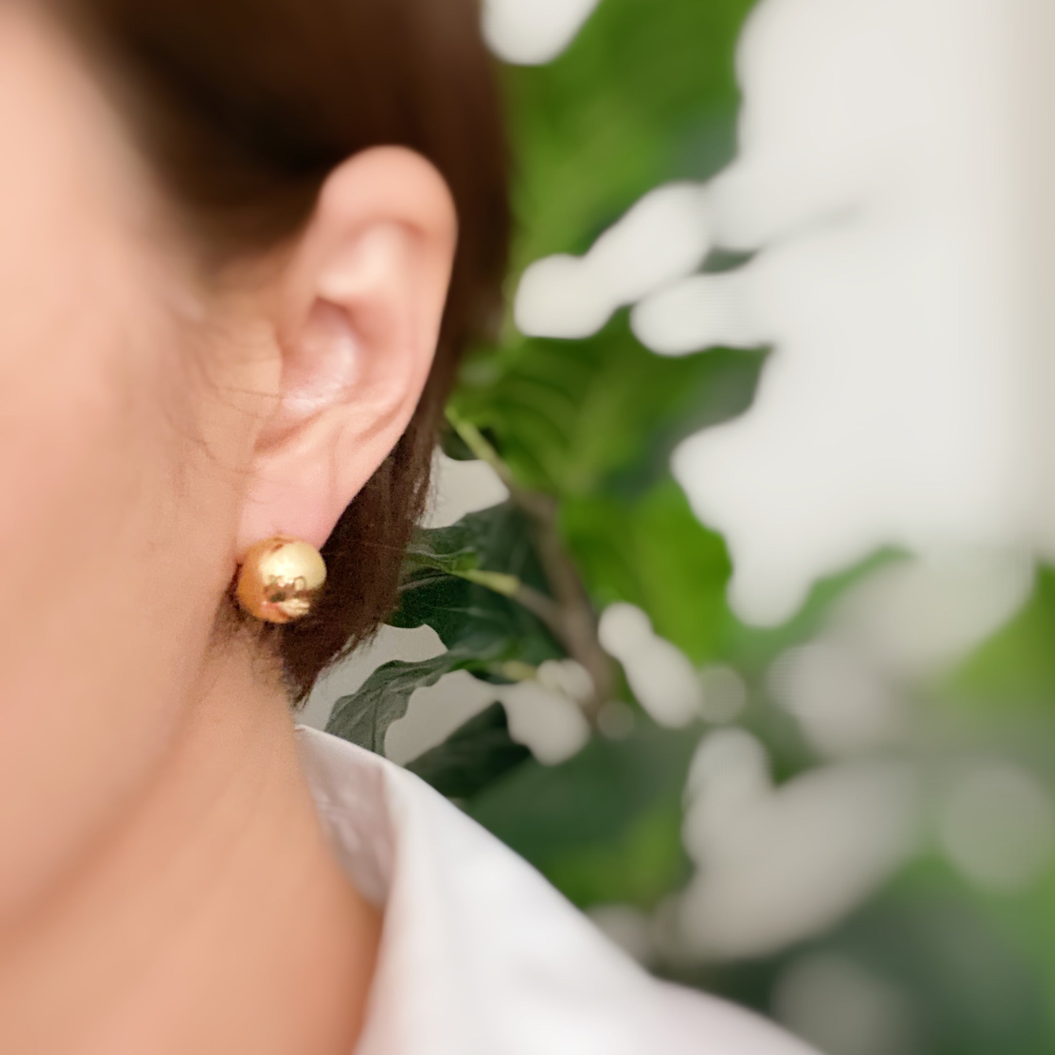 A pair of Seamlessly Round Stud Hoop Earrings in polished gold and silver finishes, showcasing their elegant and chic design.