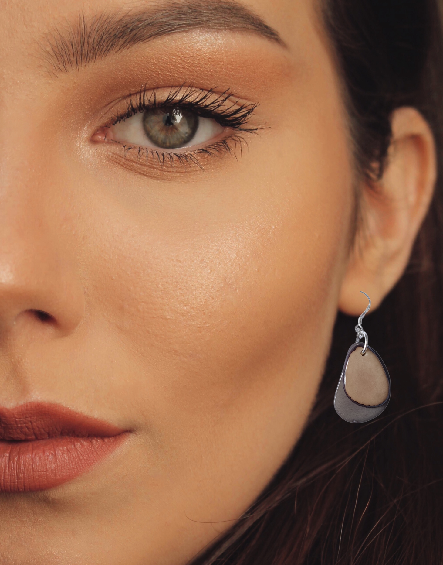 A pair of Secca Tagua Nut Earrings featuring organic vegetable ivory slices and sterling silver hooks, elegantly displayed in eco-friendly packaging.