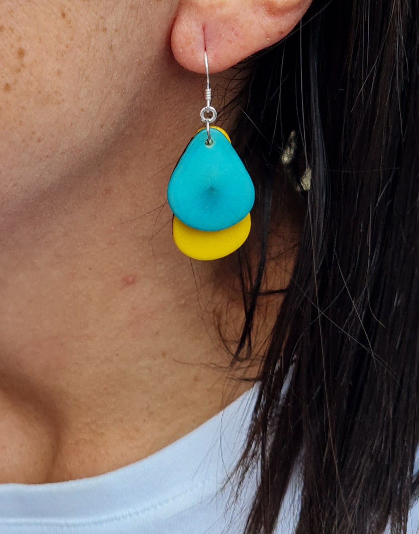 A pair of Secca Tagua Nut Earrings featuring organic vegetable ivory slices and sterling silver hooks, elegantly displayed in eco-friendly packaging.