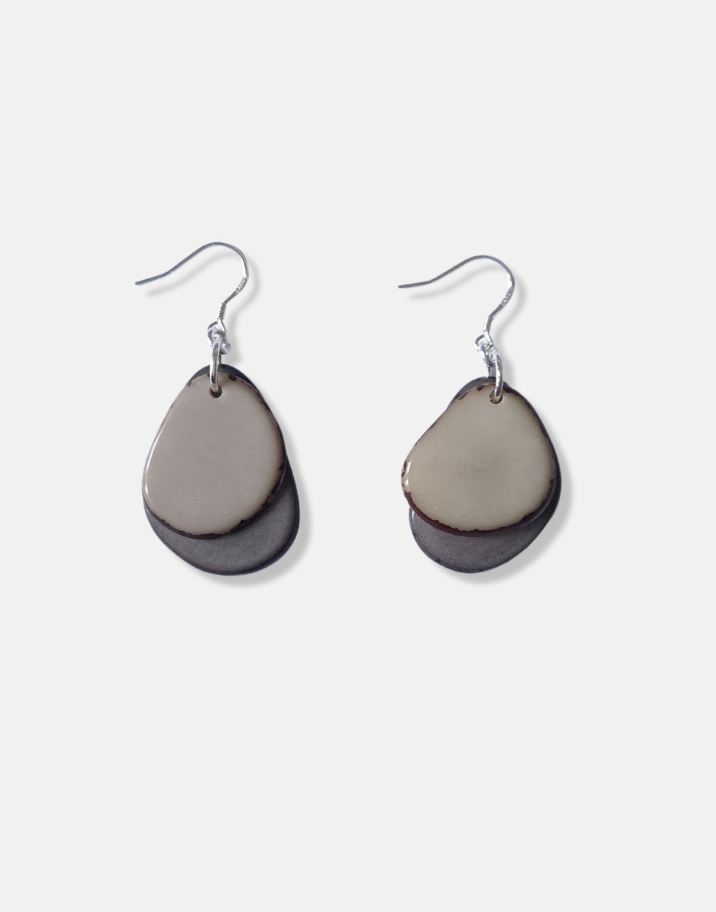 A pair of Secca Tagua Nut Earrings featuring organic vegetable ivory slices and sterling silver hooks, elegantly displayed in eco-friendly packaging.