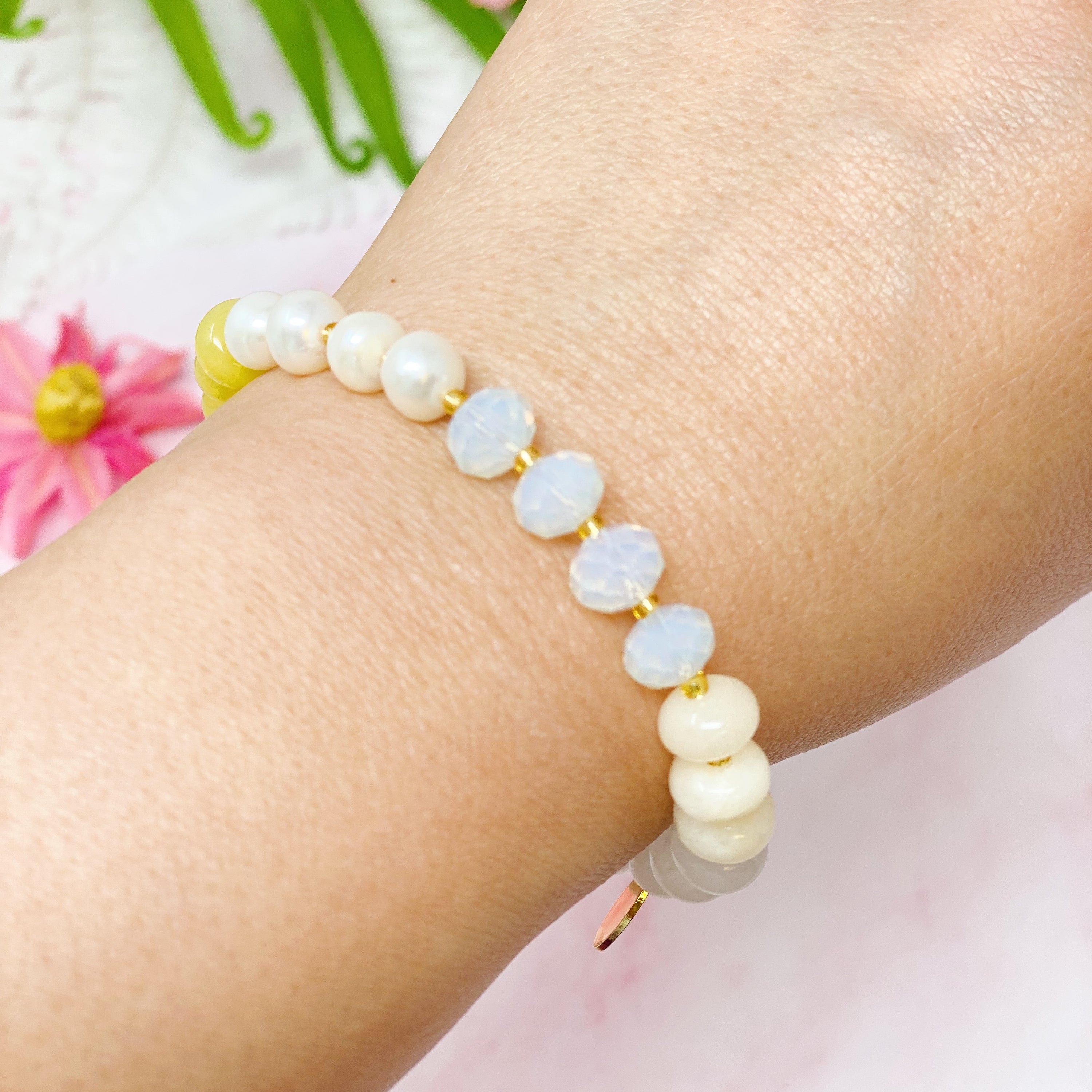 A stylish Semi-Precious Bauble Stretch Bracelet featuring natural stones, beads, and freshwater pearls with a golden logo tag.