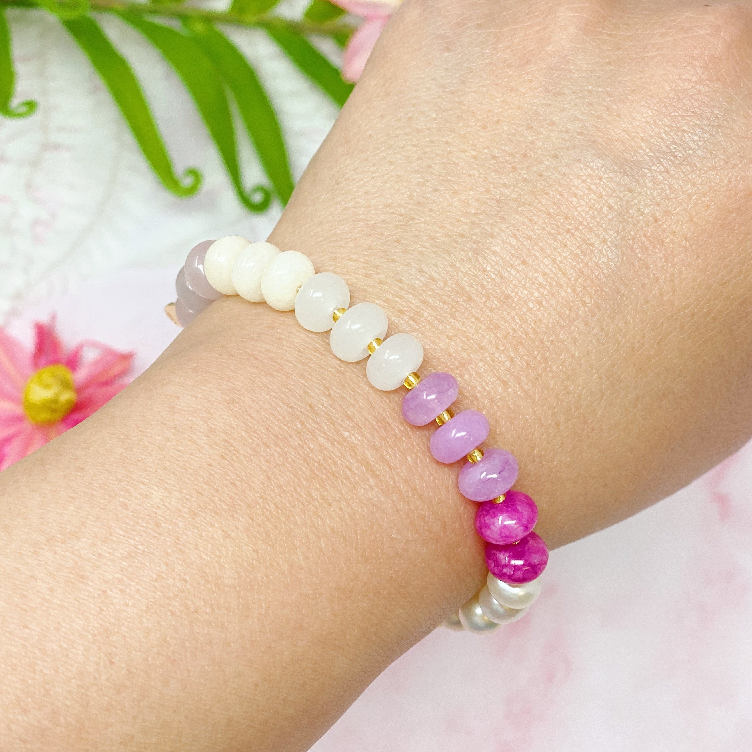 A stylish Semi-Precious Bauble Stretch Bracelet featuring natural stones, beads, and freshwater pearls with a golden logo tag.