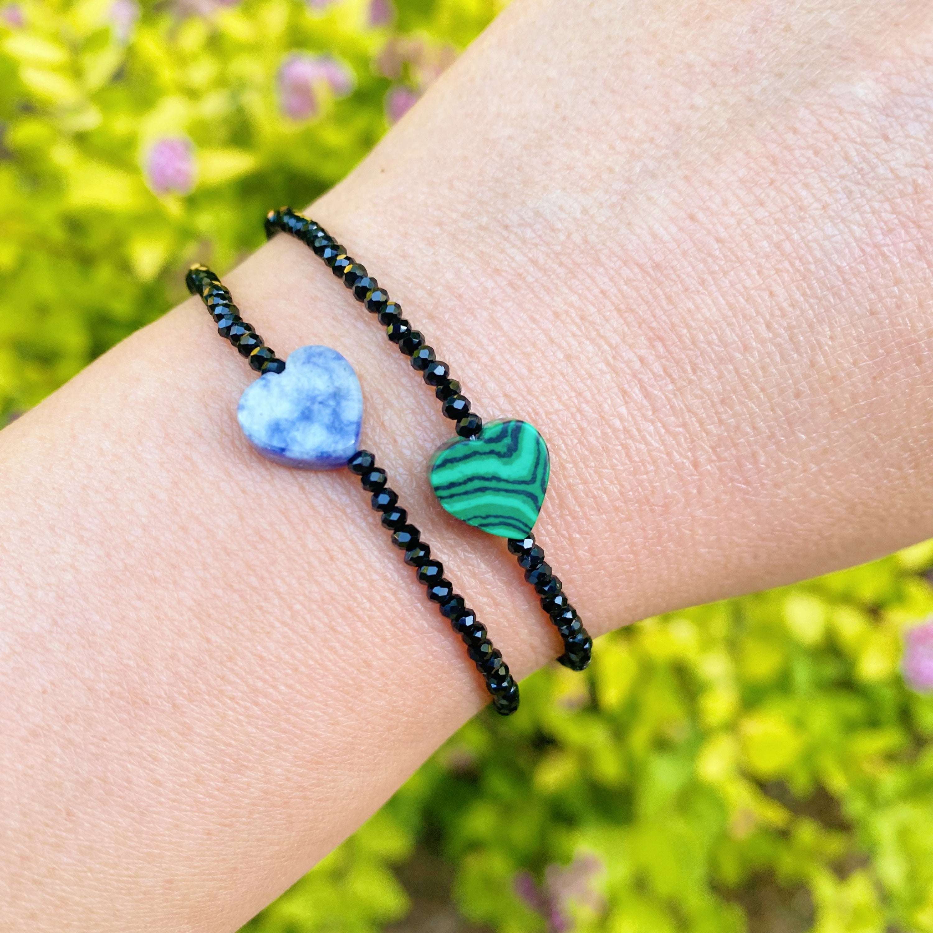 A stylish Semi-Precious Heart Stretch Bracelet featuring a natural stone heart pendant and black glass beads, showcasing a unique design.