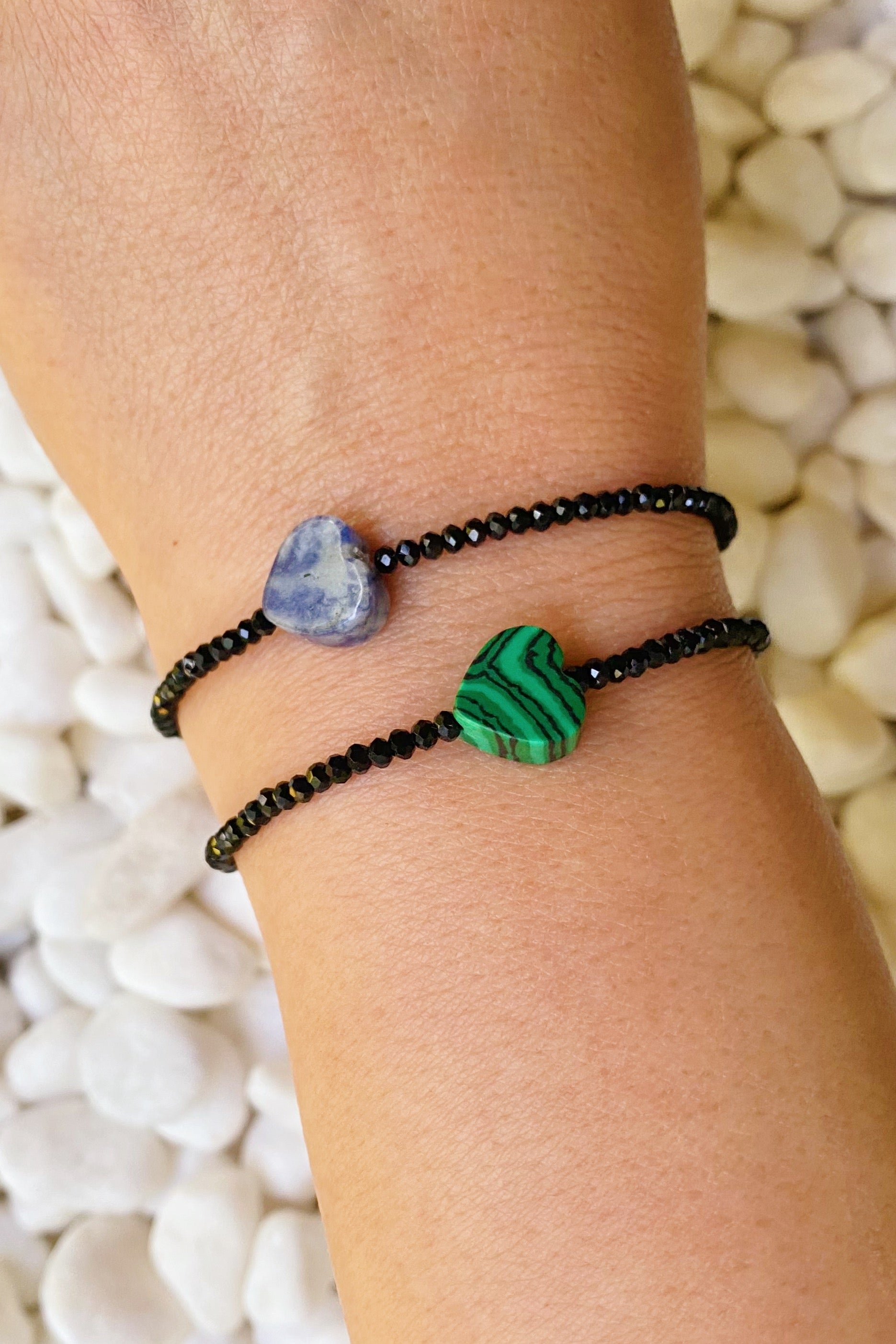 A stylish Semi-Precious Heart Stretch Bracelet featuring a natural stone heart pendant and black glass beads, showcasing a unique design.