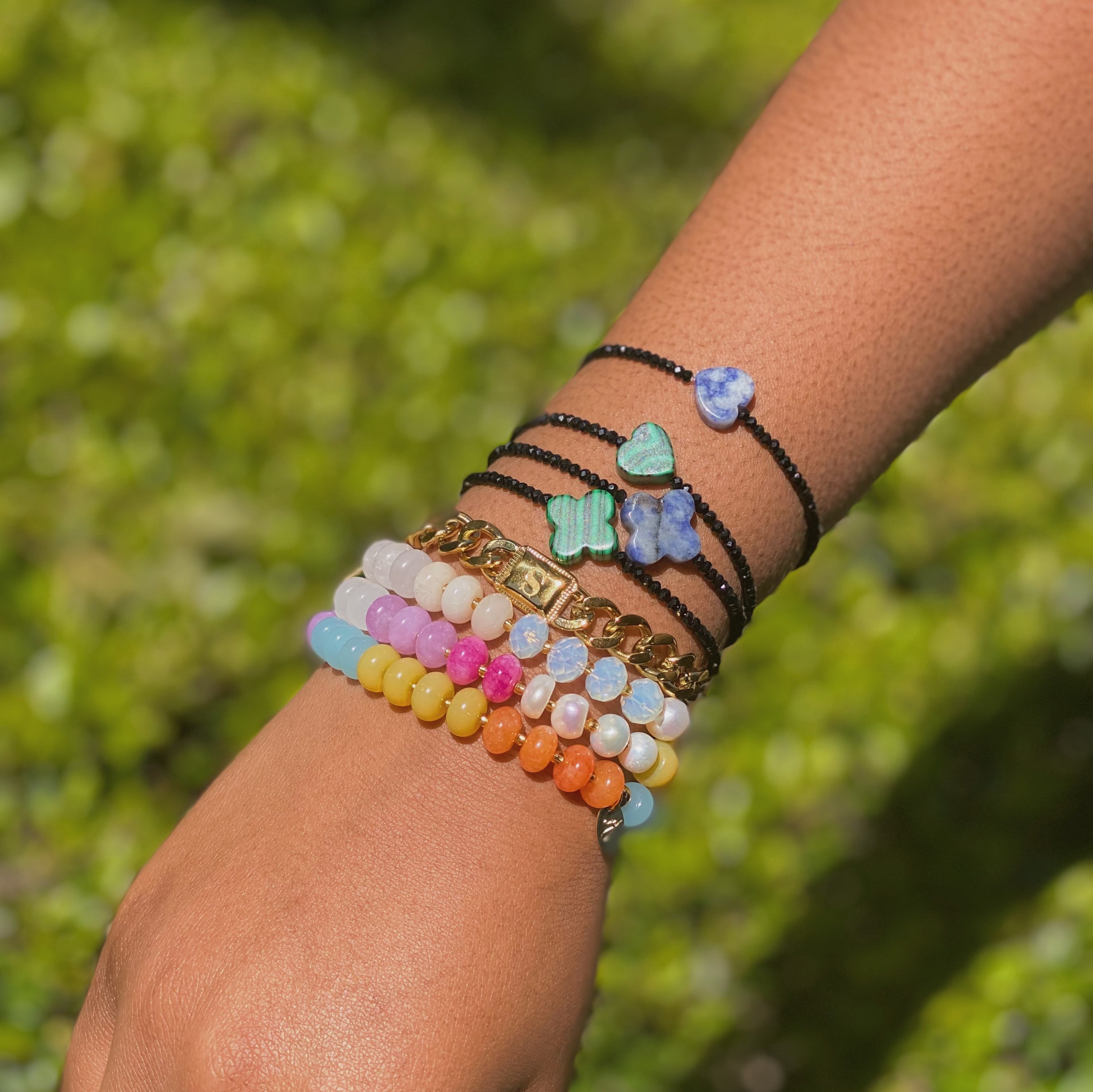 A stylish Semi-Precious Heart Stretch Bracelet featuring a natural stone heart pendant and black glass beads, showcasing a unique design.