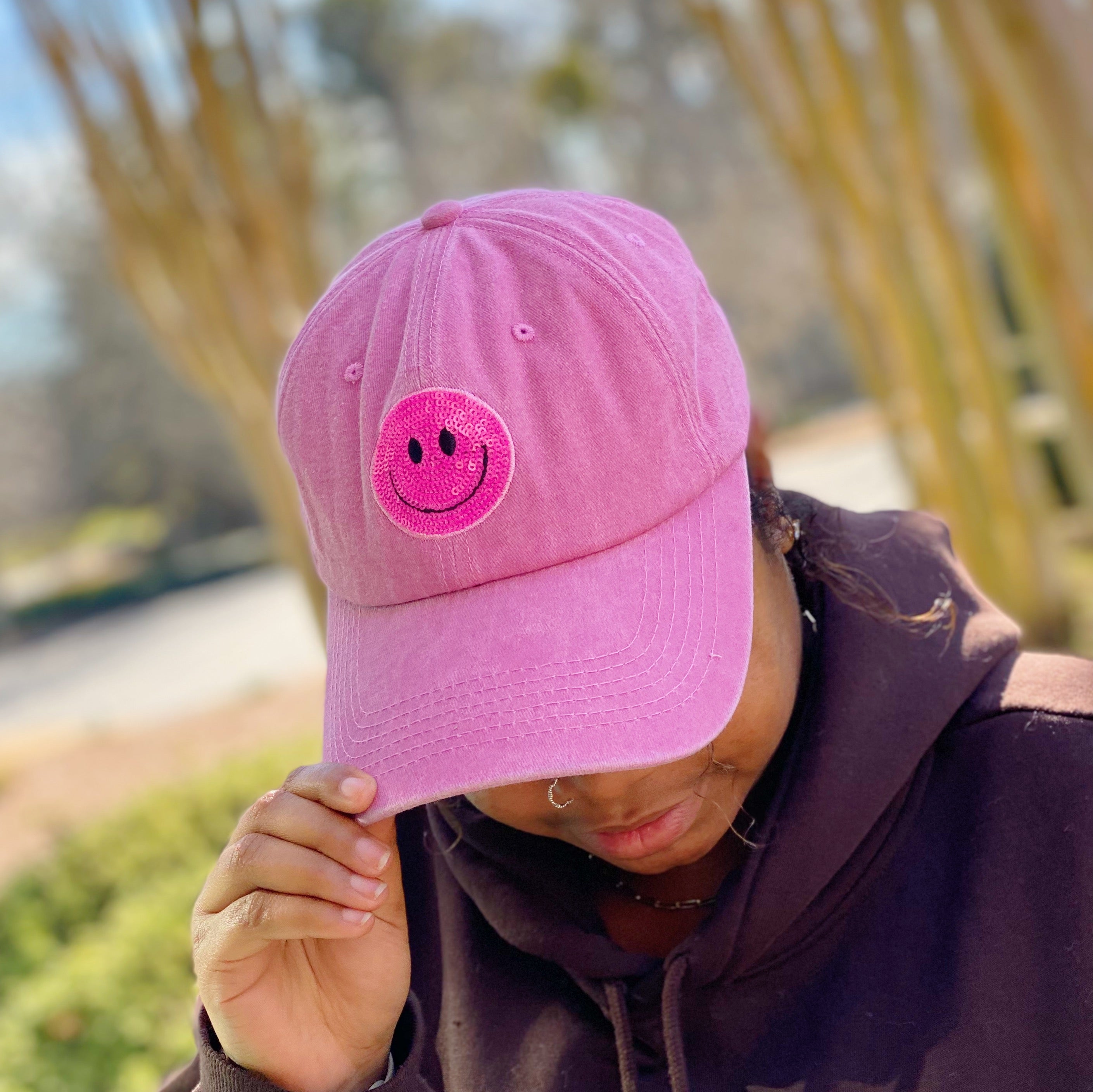 A stylish Sequin Patch Happy Ball Cap featuring a cheerful sequin happy face patch on a washed finish fabric, perfect for casual wear.