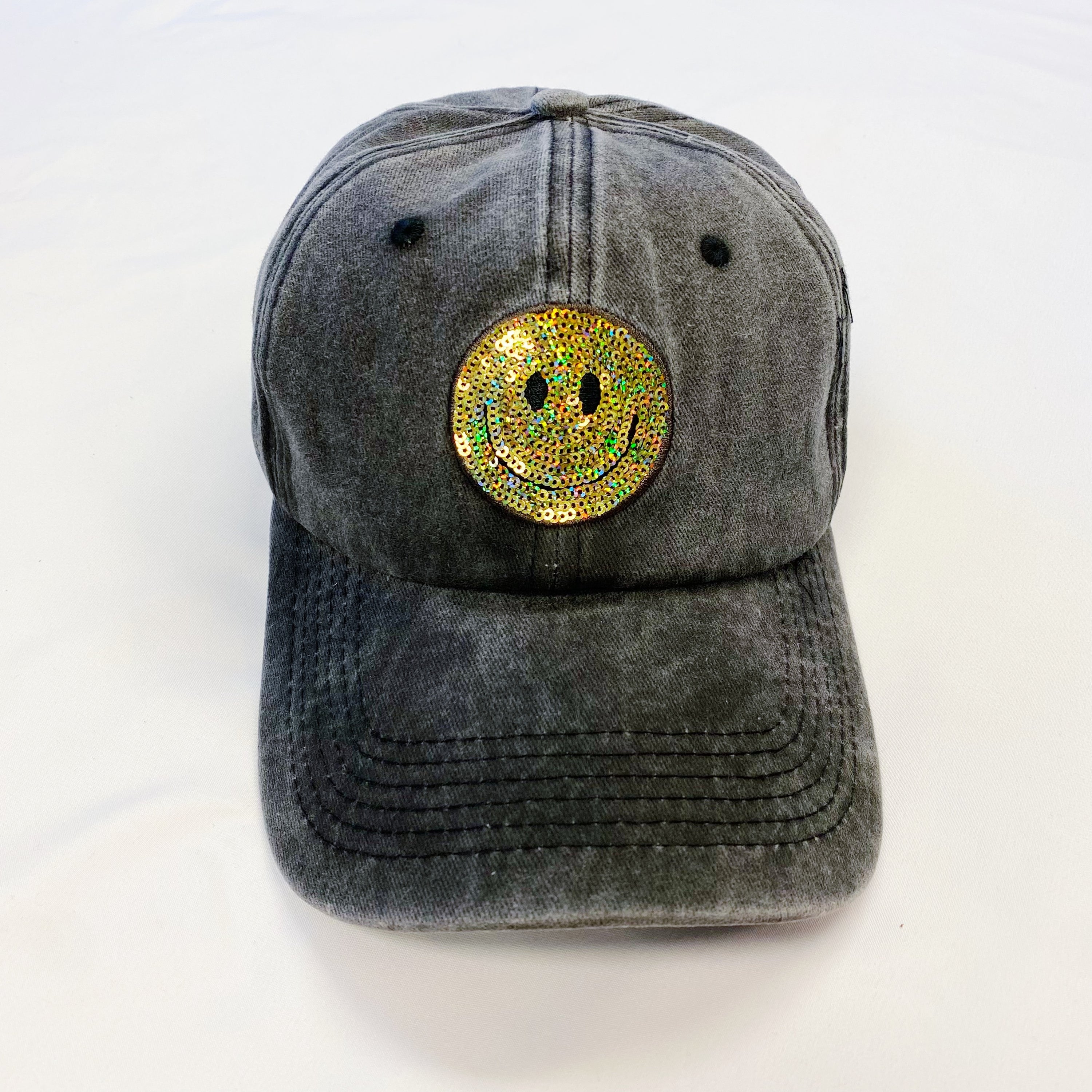 A stylish Sequin Patch Happy Ball Cap featuring a cheerful sequin happy face patch on a washed finish fabric, perfect for casual wear.