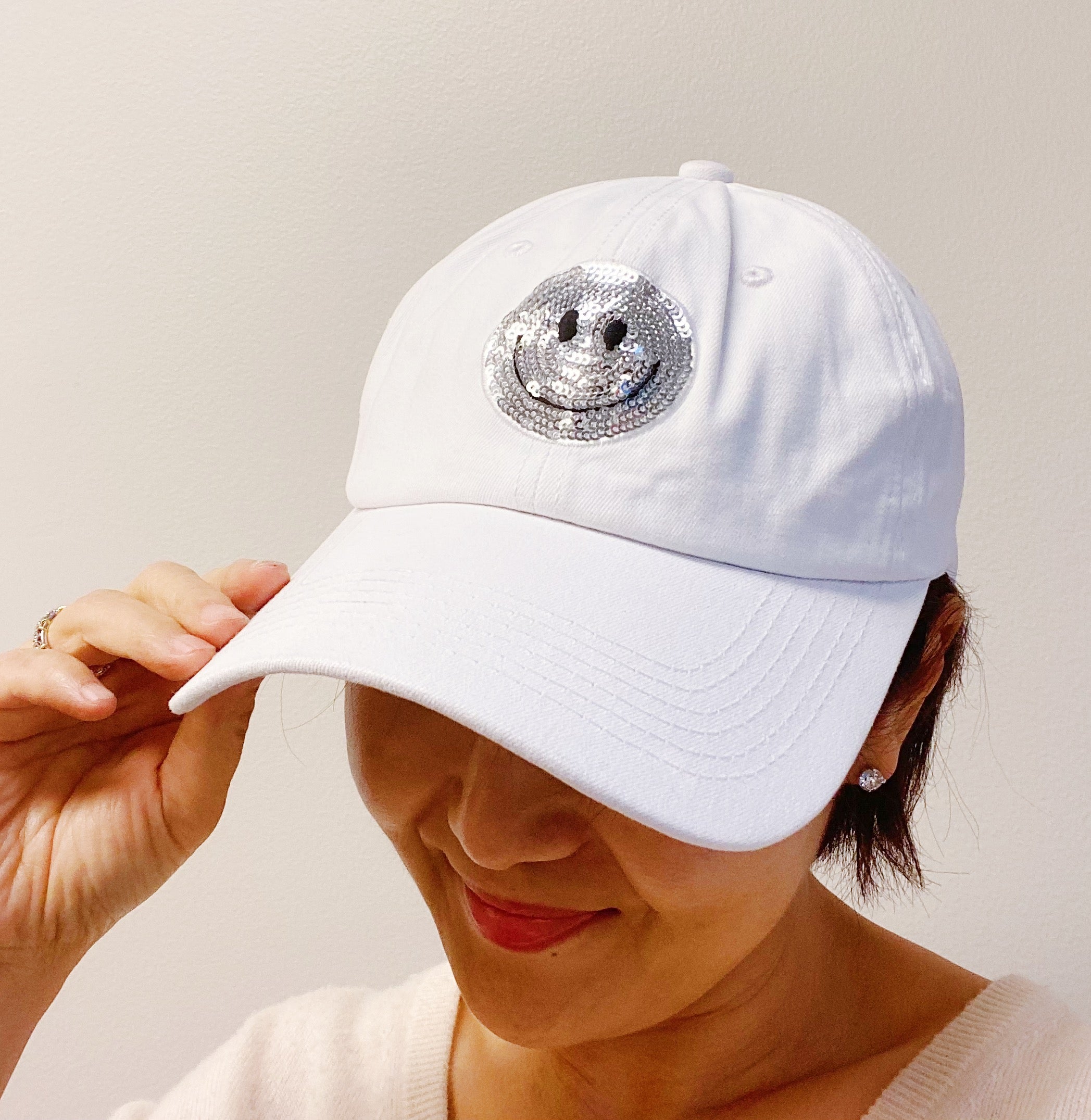 A stylish Sequin Patch Happy Ball Cap featuring a cheerful sequin happy face patch on a washed finish fabric, perfect for casual wear.