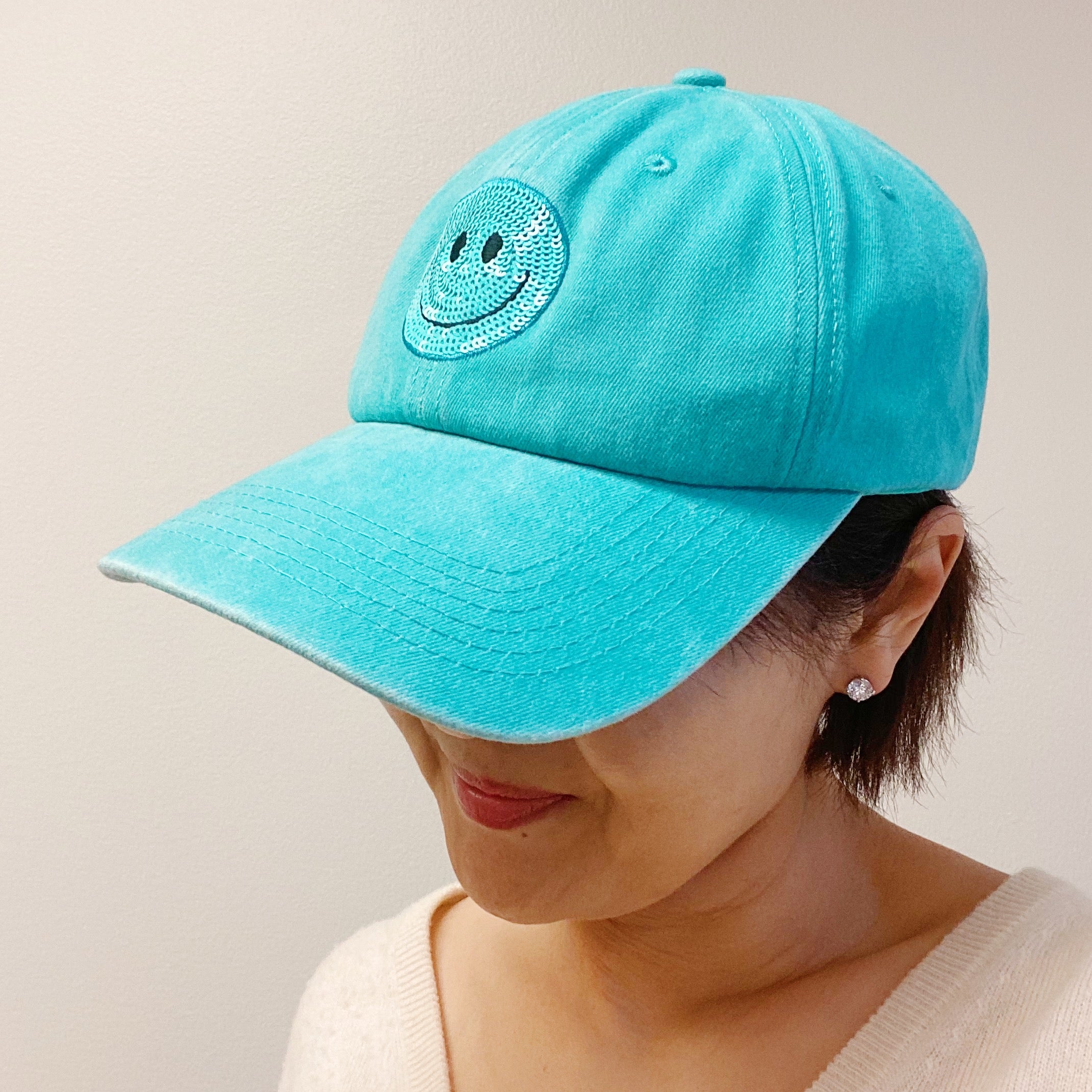 A stylish Sequin Patch Happy Ball Cap featuring a cheerful sequin happy face patch on a washed finish fabric, perfect for casual wear.