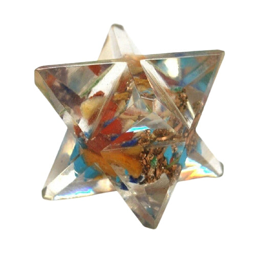 A Seven Chakra Orgone Merkaba made of translucent resin with seven colorful chakra gemstone chips, shaped like an eight-pointed star.