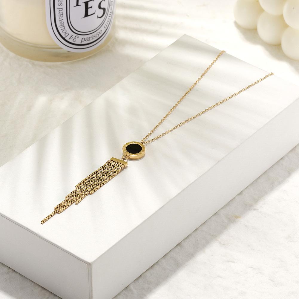 SHELL ACRYLIC TASSEL PENDANT featuring natural shell and black acrylic with 14k gold accents on a delicate chain.