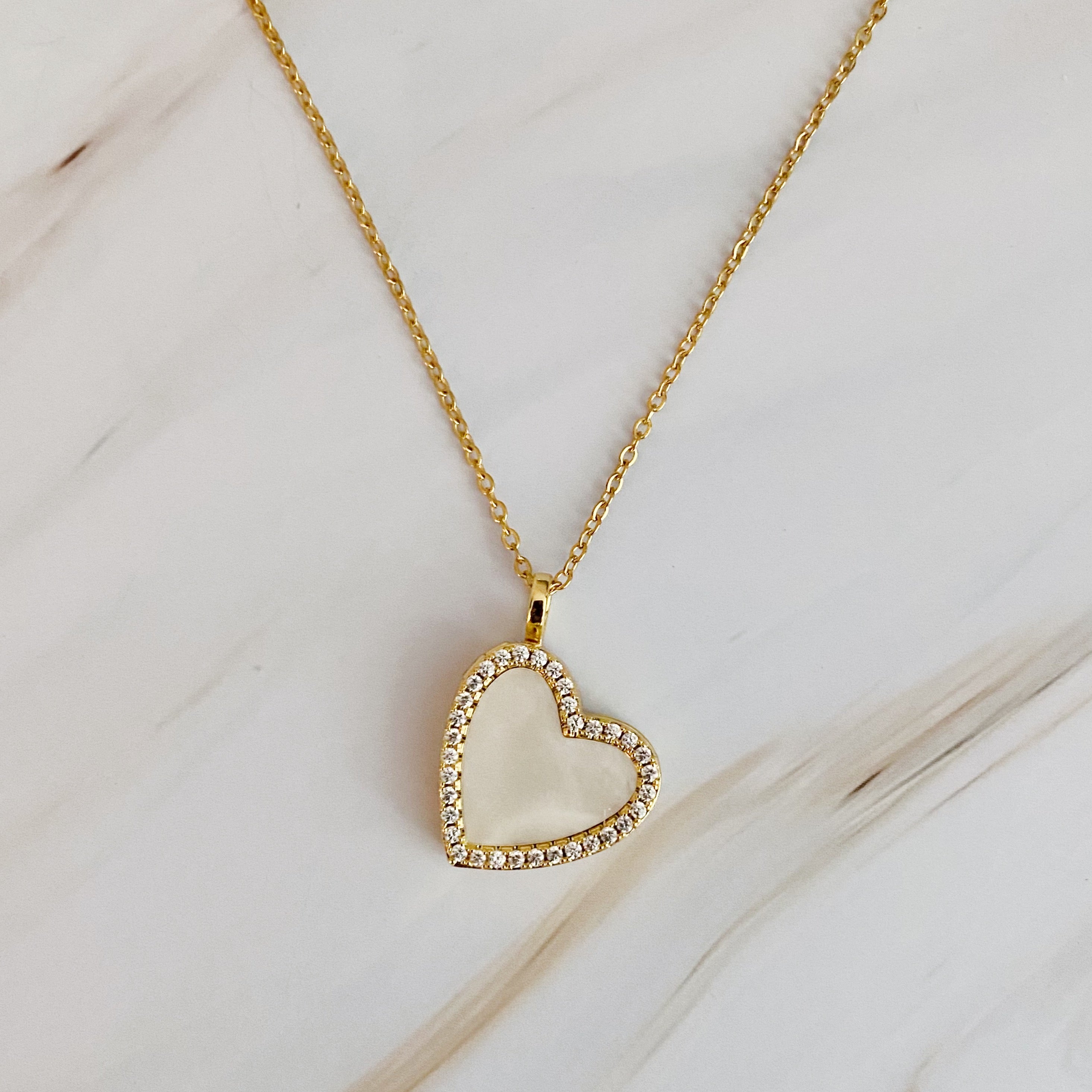 Elegant Shell Heart Locket Pendant Necklace with mother of pearl and gold plating, featuring a delicate design and adjustable chain.