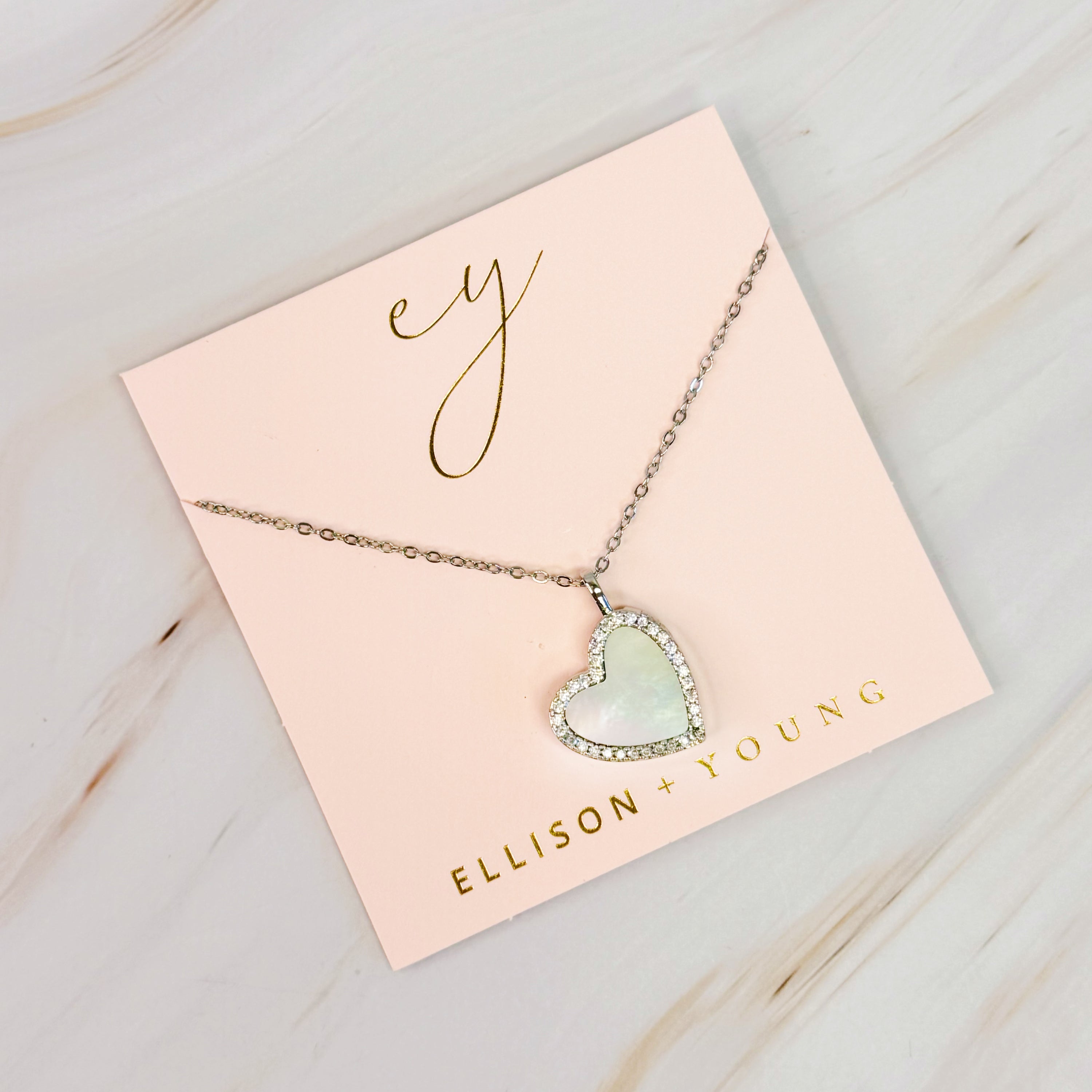 Elegant Shell Heart Locket Pendant Necklace with mother of pearl and gold plating, featuring a delicate design and adjustable chain.