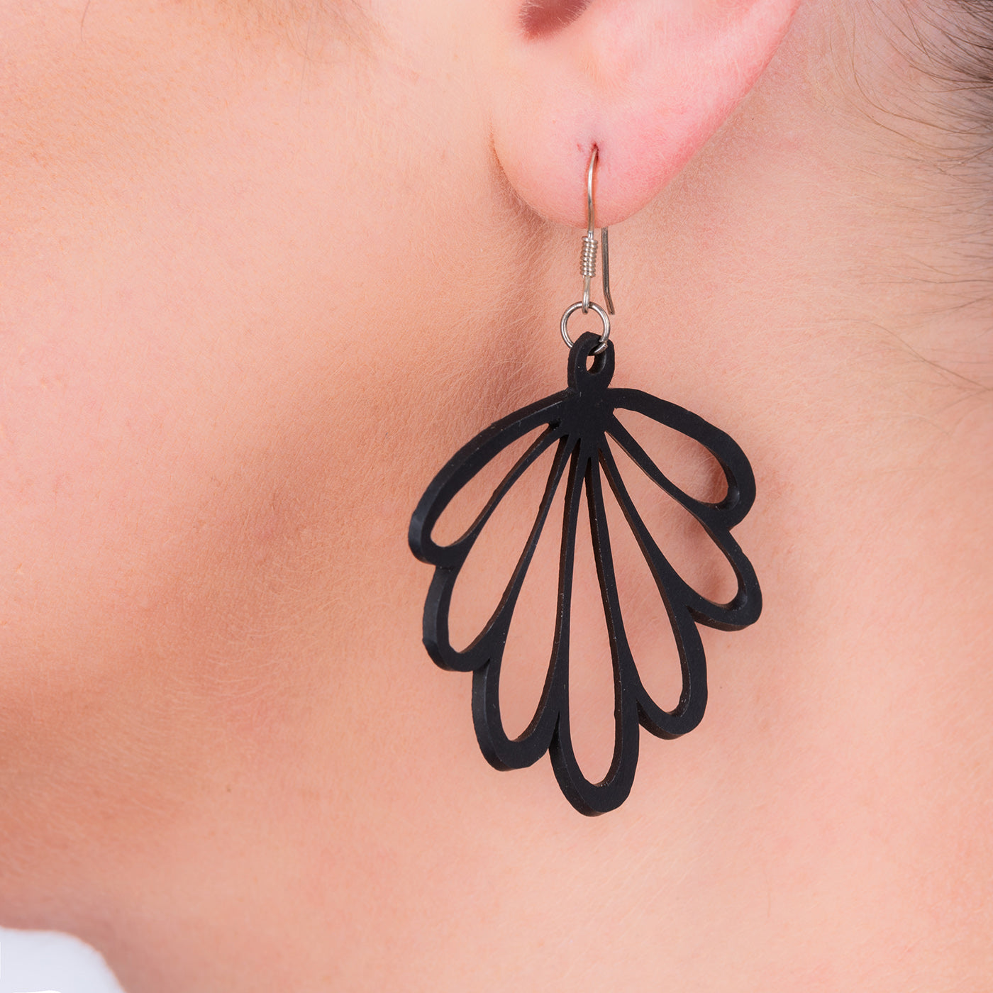 A pair of handmade Shell Recycled Rubber Earrings featuring unique patterns and sterling silver hooks, showcasing eco-friendly fashion.