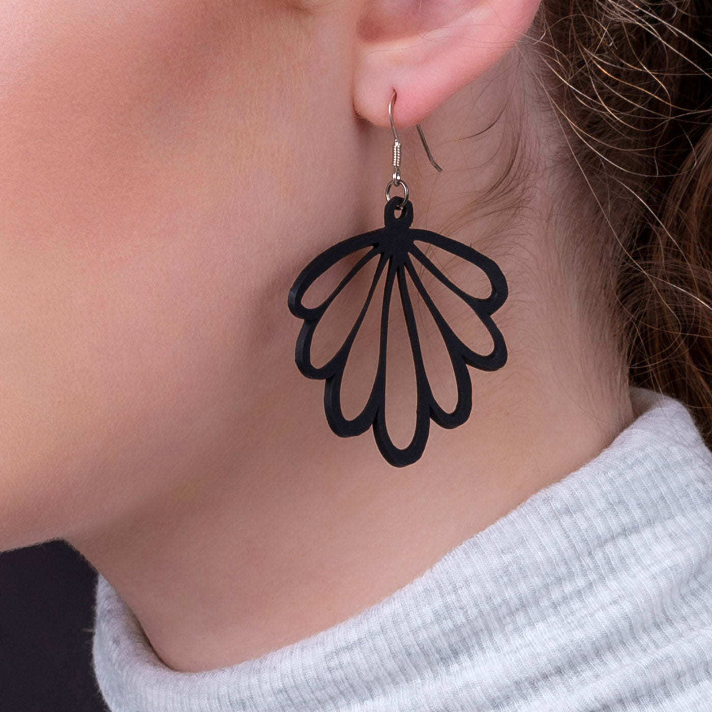 A pair of handmade Shell Recycled Rubber Earrings featuring unique patterns and sterling silver hooks, showcasing eco-friendly fashion.